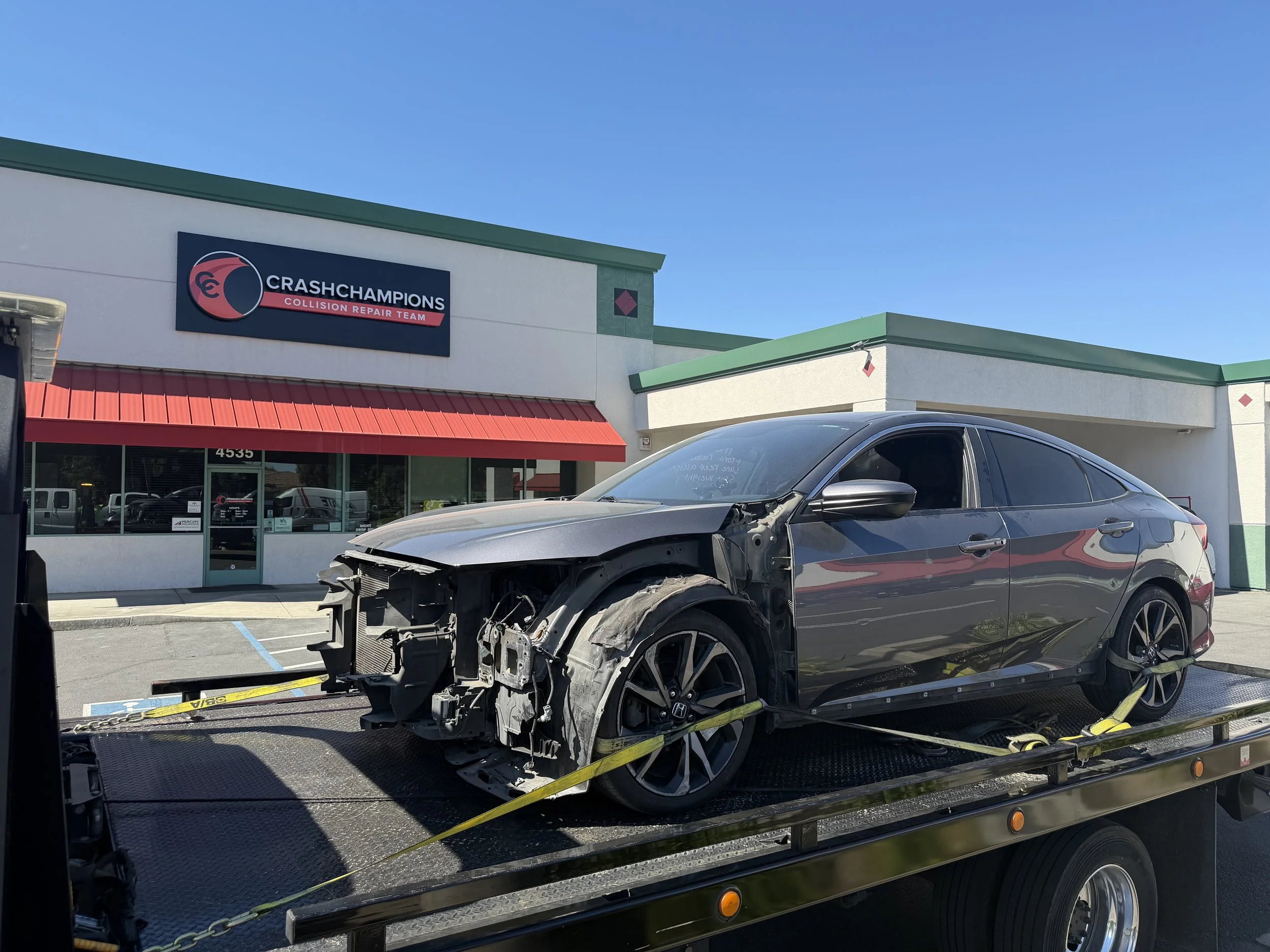 “24-7 Rescue Towing transporting a damaged Honda sedan on a flatbed tow truck to a collision repair shop in Antioch, California.”
