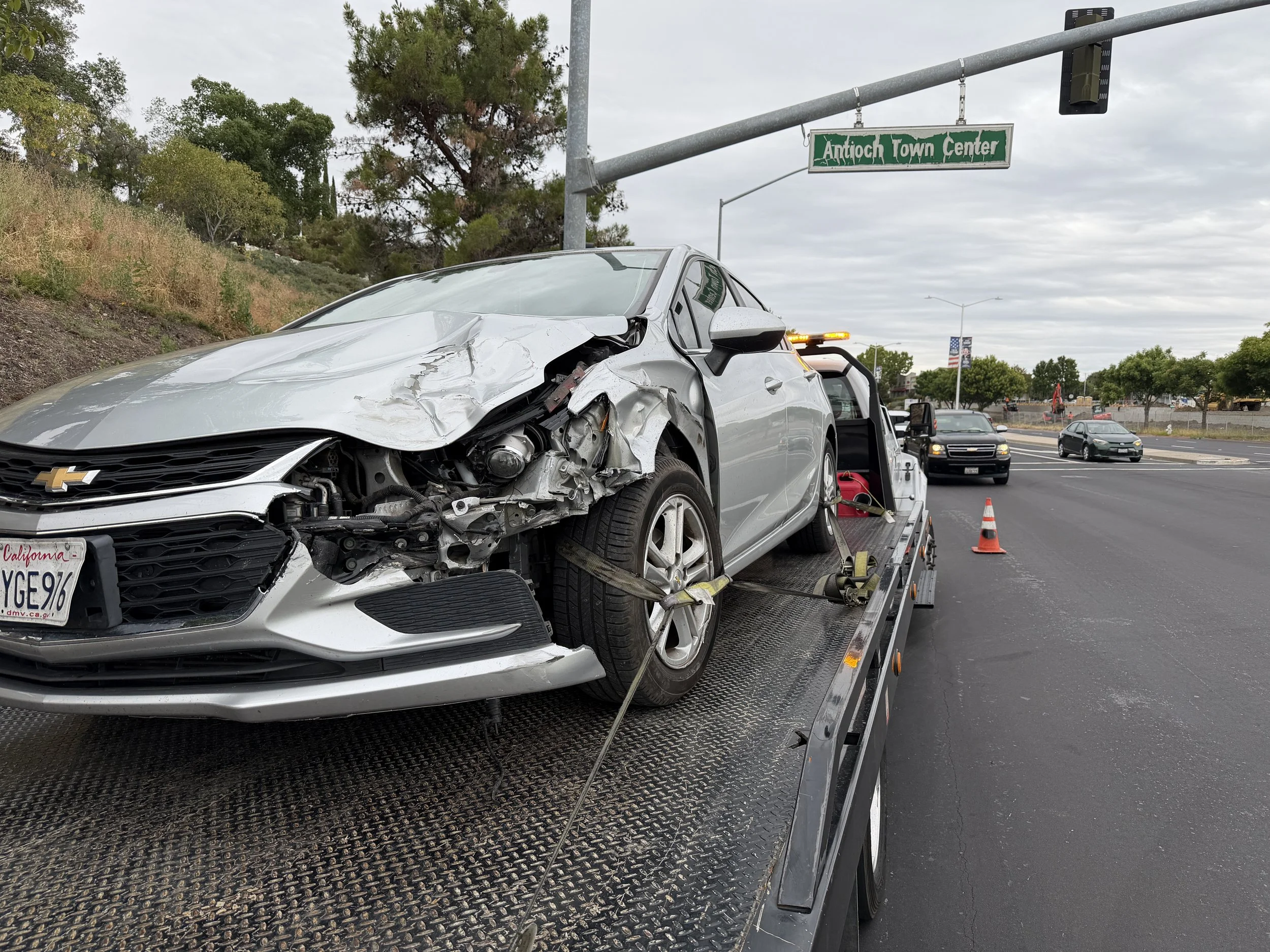 Accident recovery towing service in Antioch CA near Antioch Town Center. Damaged Chevrolet sedan safely loaded onto a flatbed tow truck by 24-7 Rescue Towing after a traffic collision.