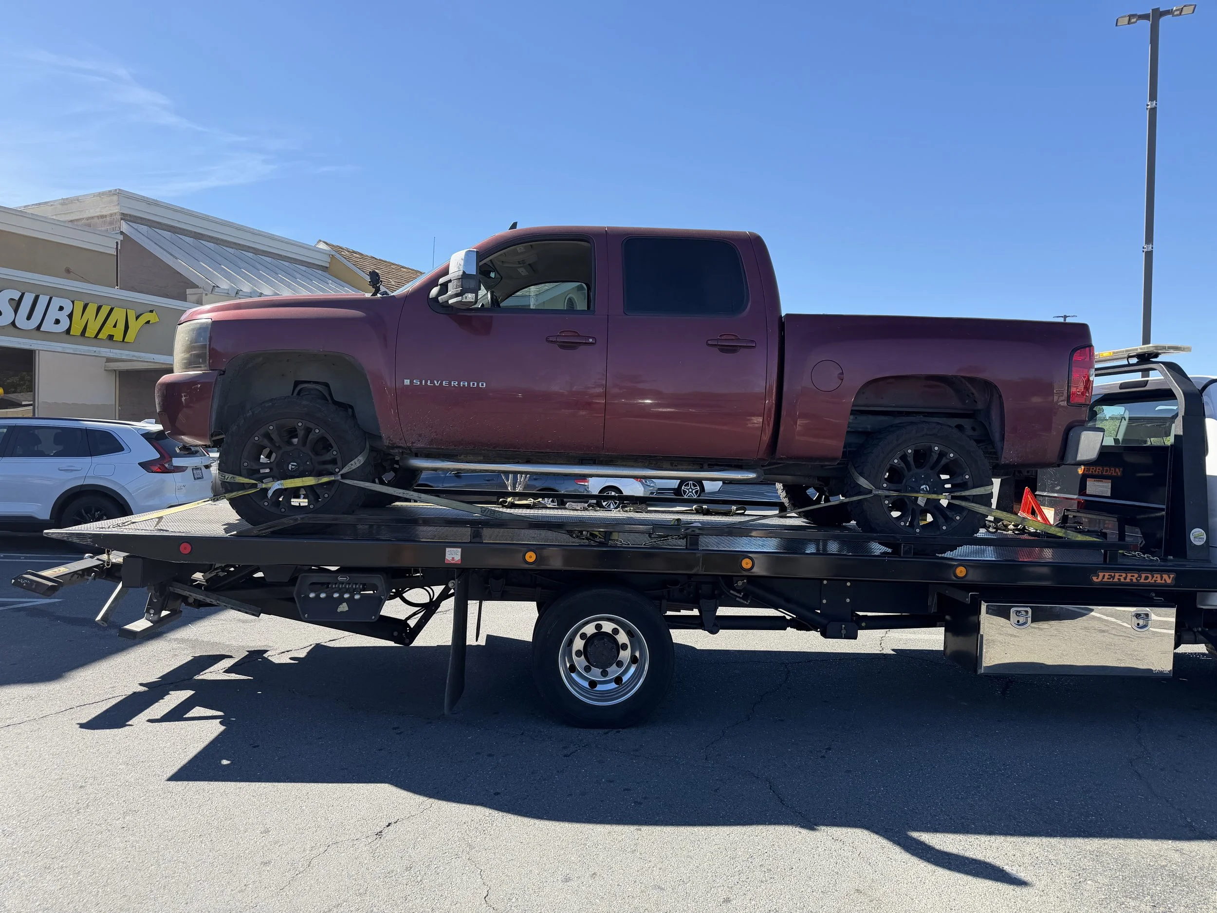 Tow truck near me in Antioch CA loading a Chevrolet Silverado onto a flatbed tow truck for safe transport by 24-7 Rescue Towing.