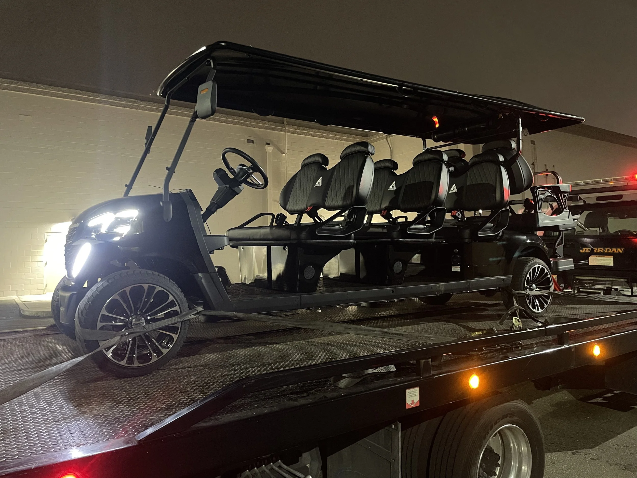 24-7 Rescue Towing transporting a luxury golf cart on a flatbed tow truck in Discovery Bay, California at night