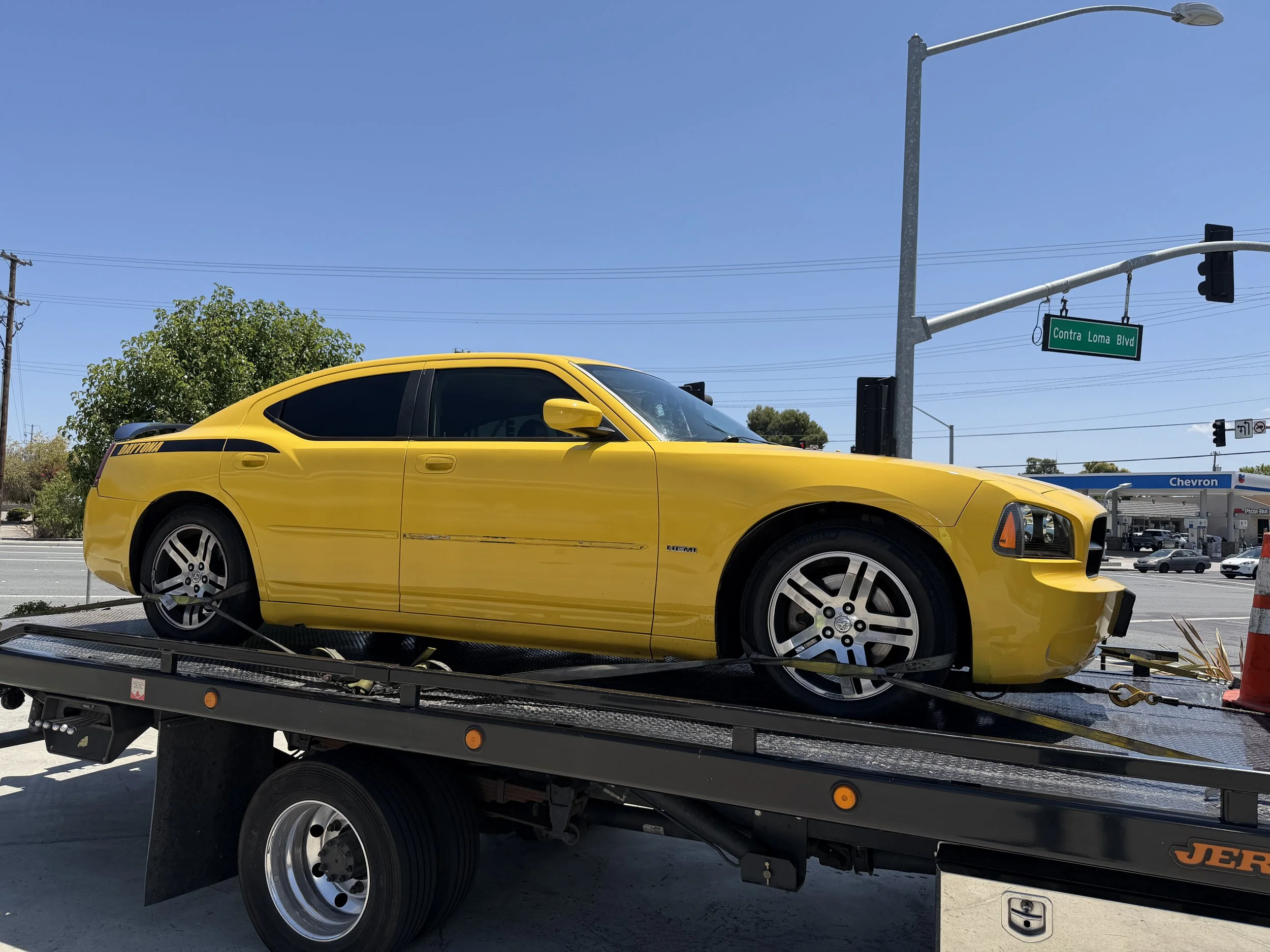 Yellow Dodge Charger Daytona loaded on flatbed tow truck in Antioch CA