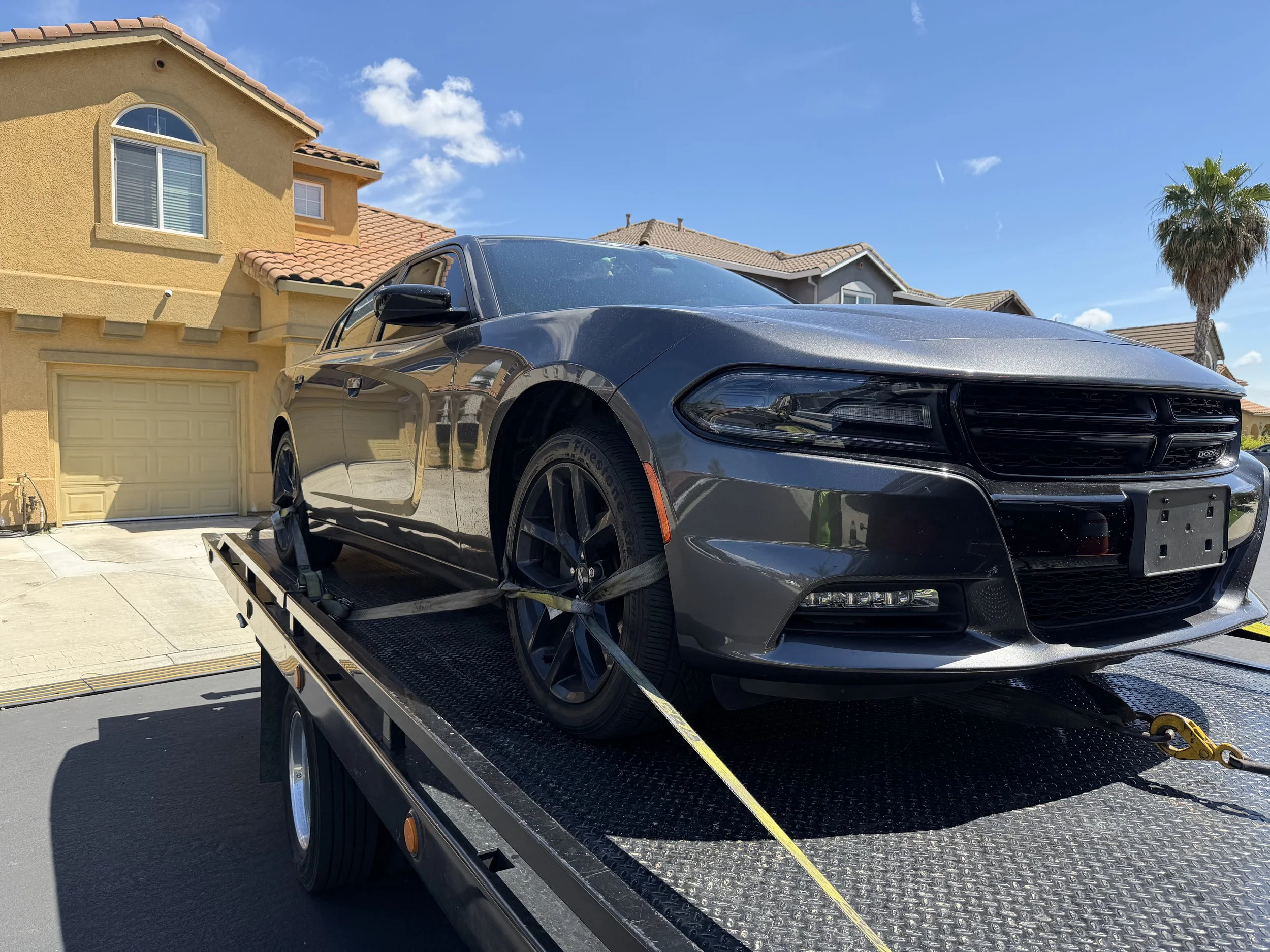 24-7 Rescue Towing transporting a Dodge Charger on a flatbed tow truck in Discovery Bay, California