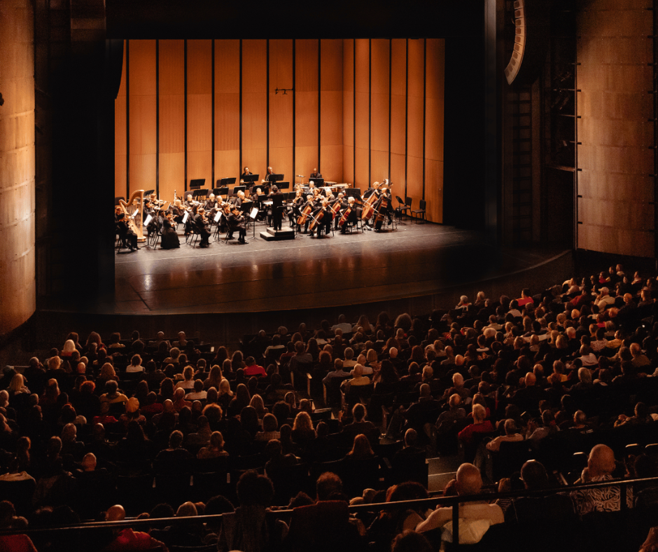 A wide shot of Chicago Sinfonietta at Harris Theater with a full audience.
