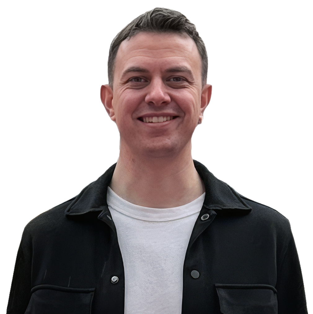 A headshot of Grant Russell in a black button down shirt and white t-shirt.