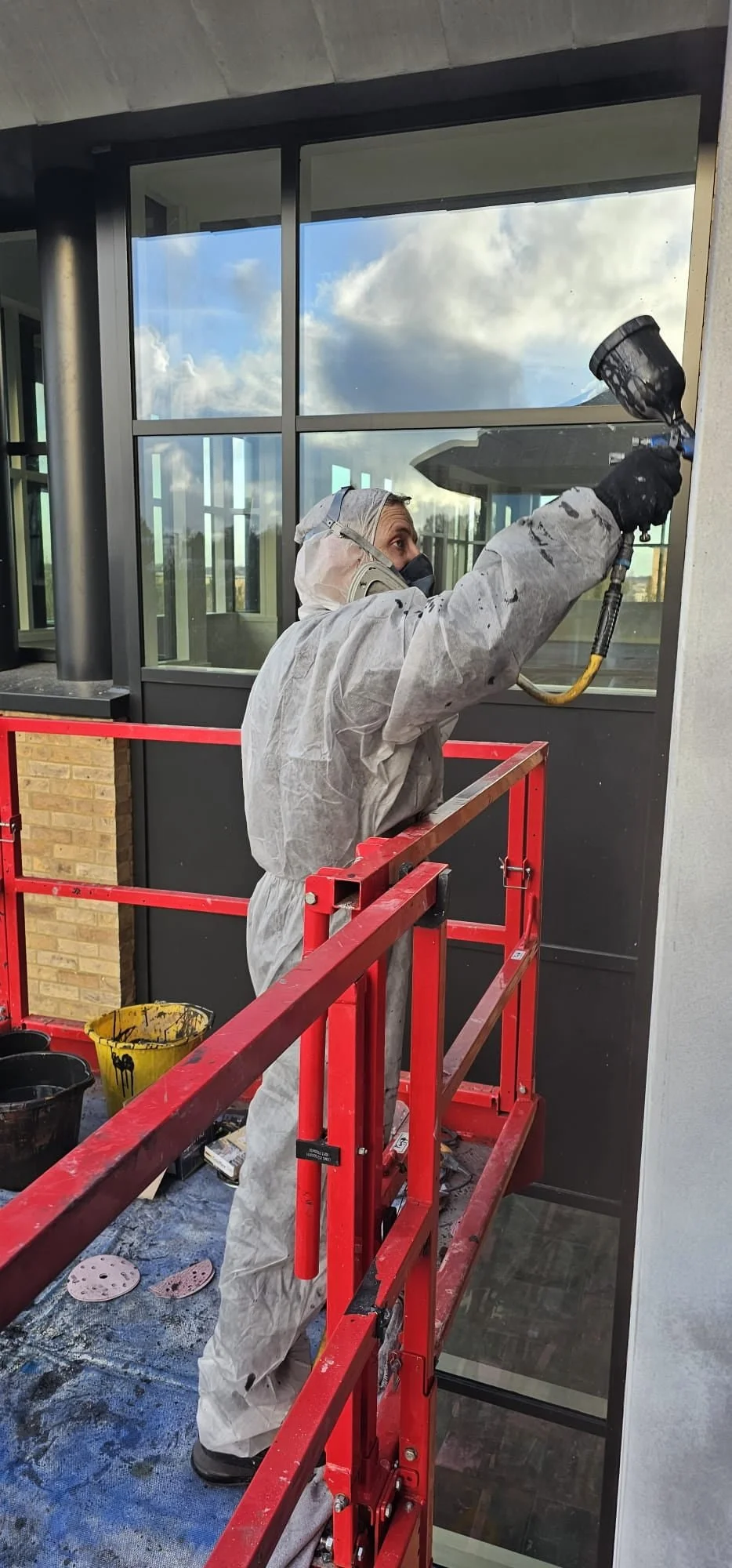Our staff spraying cladding on a cherry picker