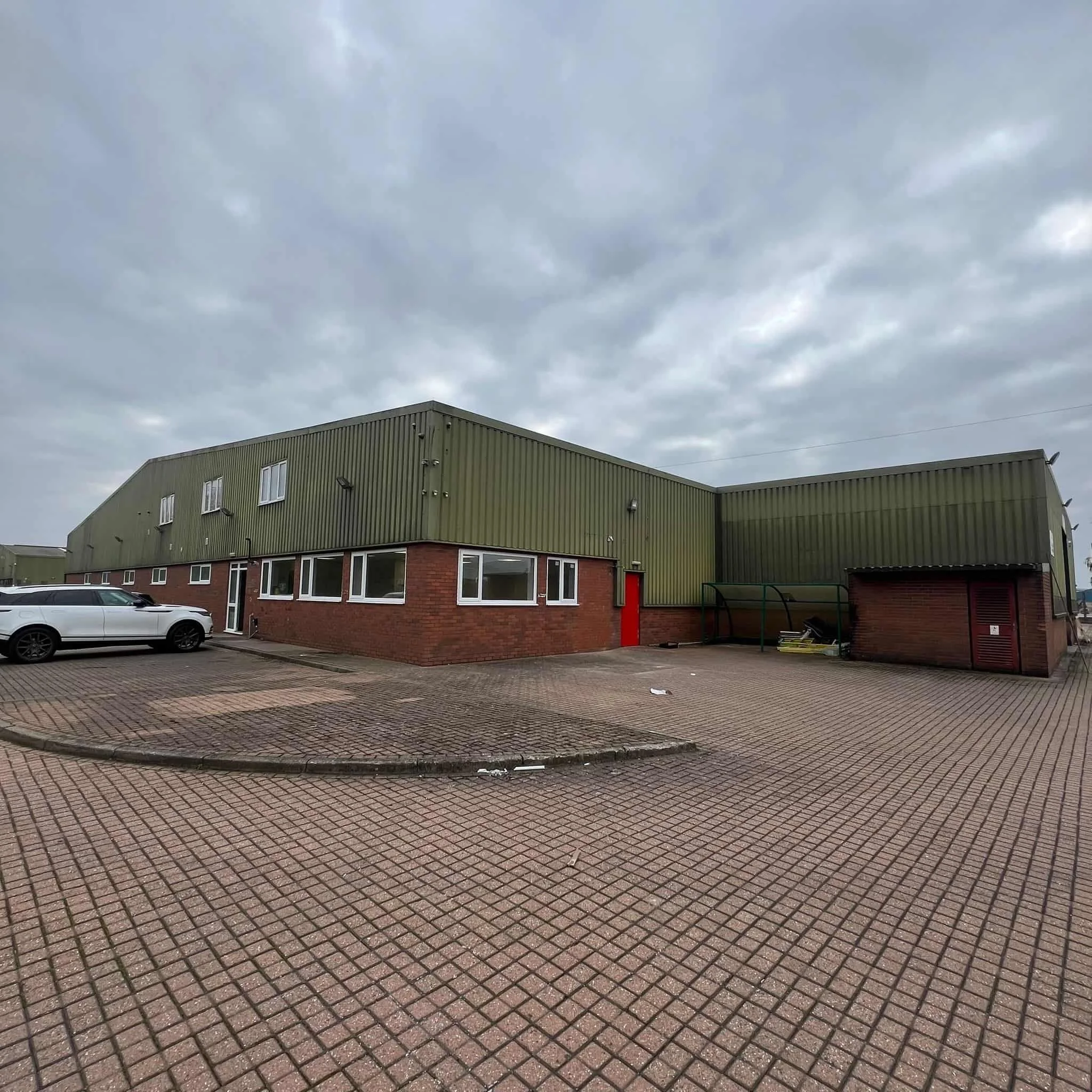 Front view of faded and weathered industrial cladding at Waterside Business Park in Burton-on-Trent before restoration