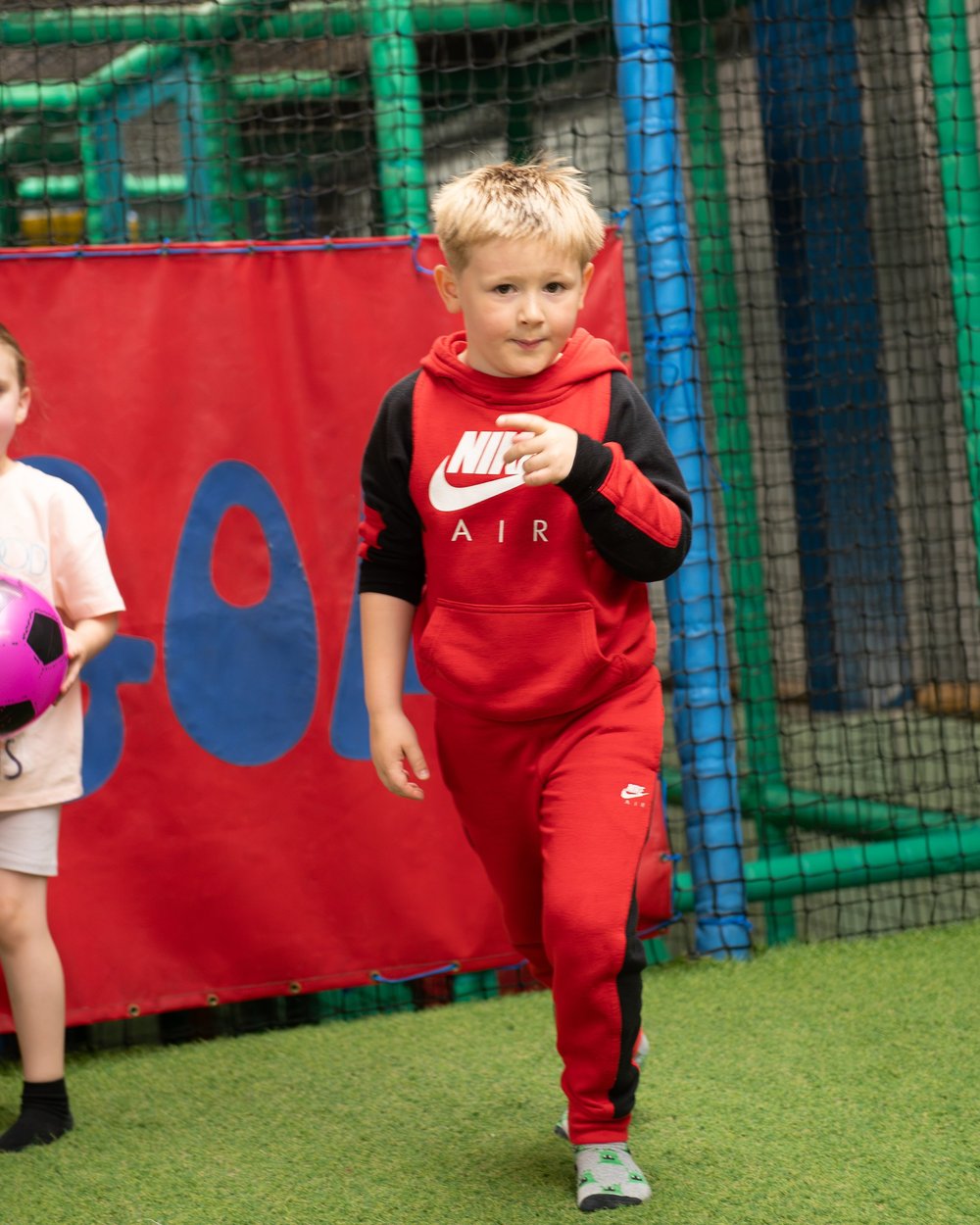 Child enjoying the indoor football area at Diddy Middy's