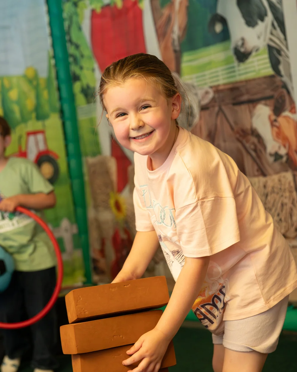 Child smiling in a themed play area at Diddy Middy's