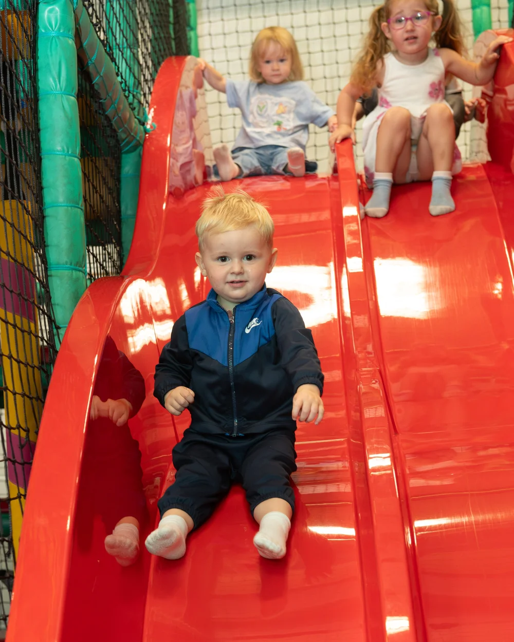 Children enjoying the red slide at Diddy Middys soft play
