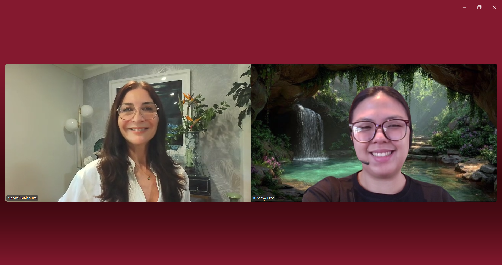 Two women in a video call, one with long dark hair and glasses smiling in a well-decorated room, the other with short hair and glasses smiling with a tropical waterfall background.