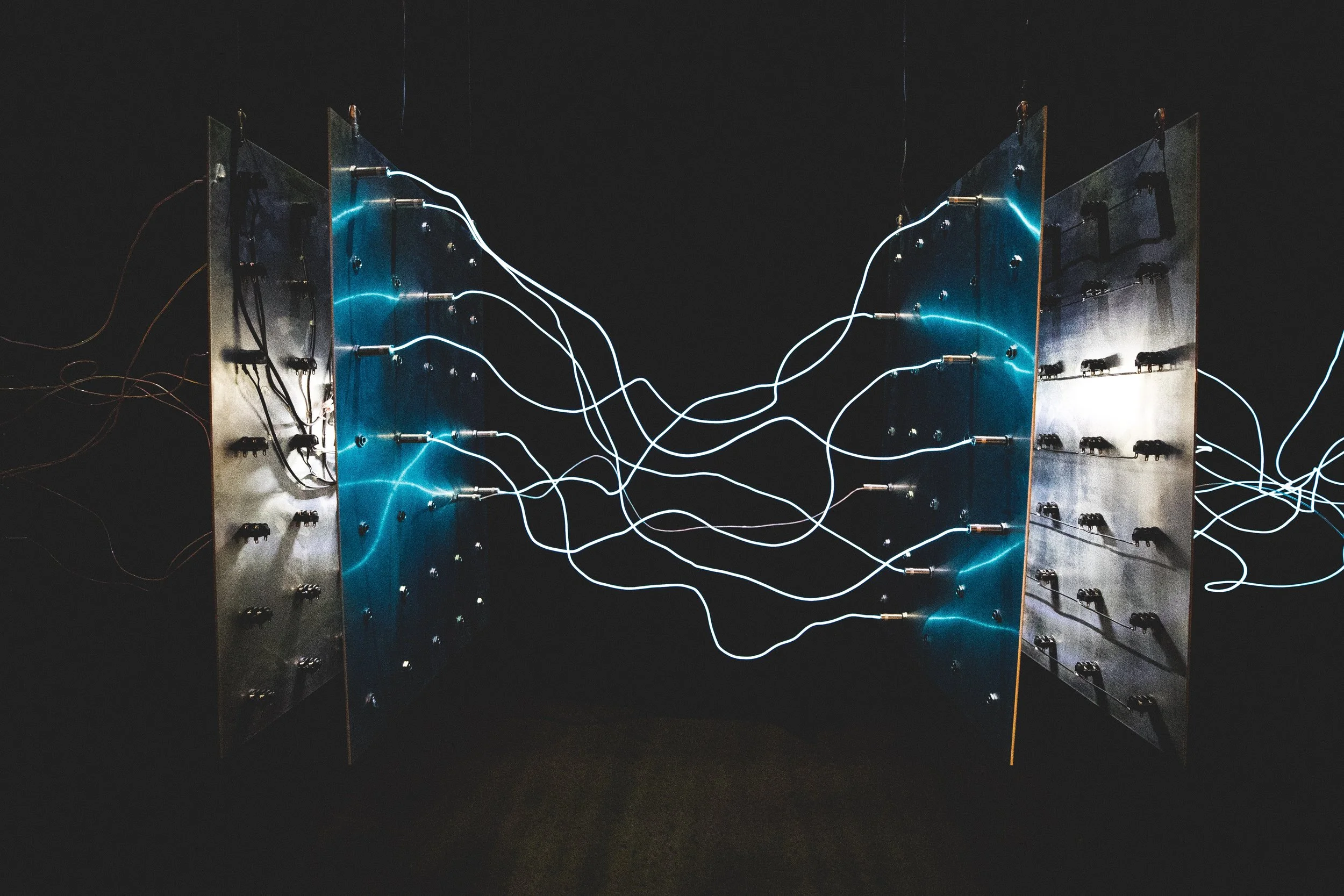 Künstliche neuronale Netzwerke mit leuchtenden blauen Linien, die zwischen metallischen Scheiben verbunden sind.