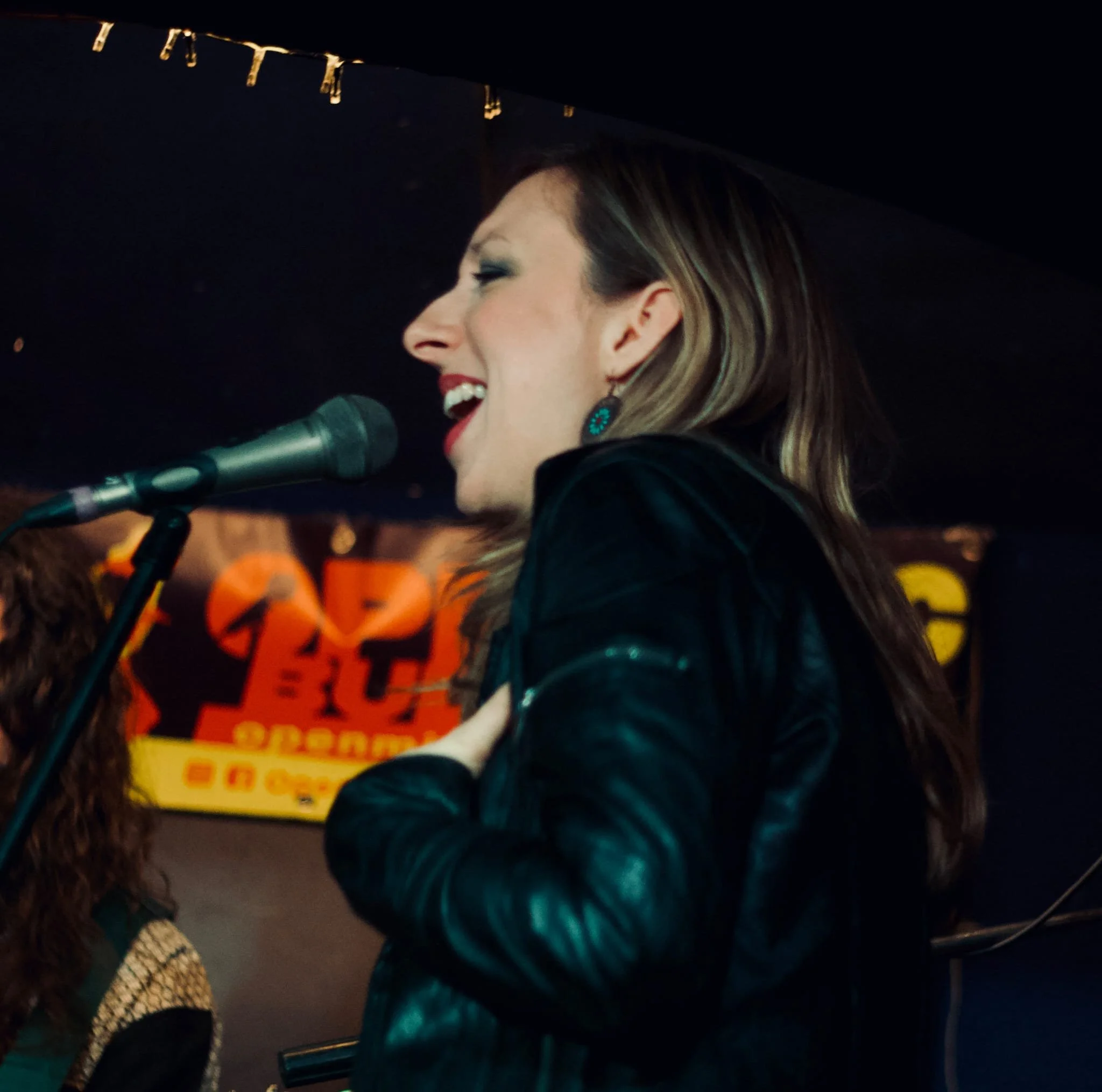 Singing my own song on stage at Lámpás Pub, welcoming the New Year with my voice, my body, and my full presence.