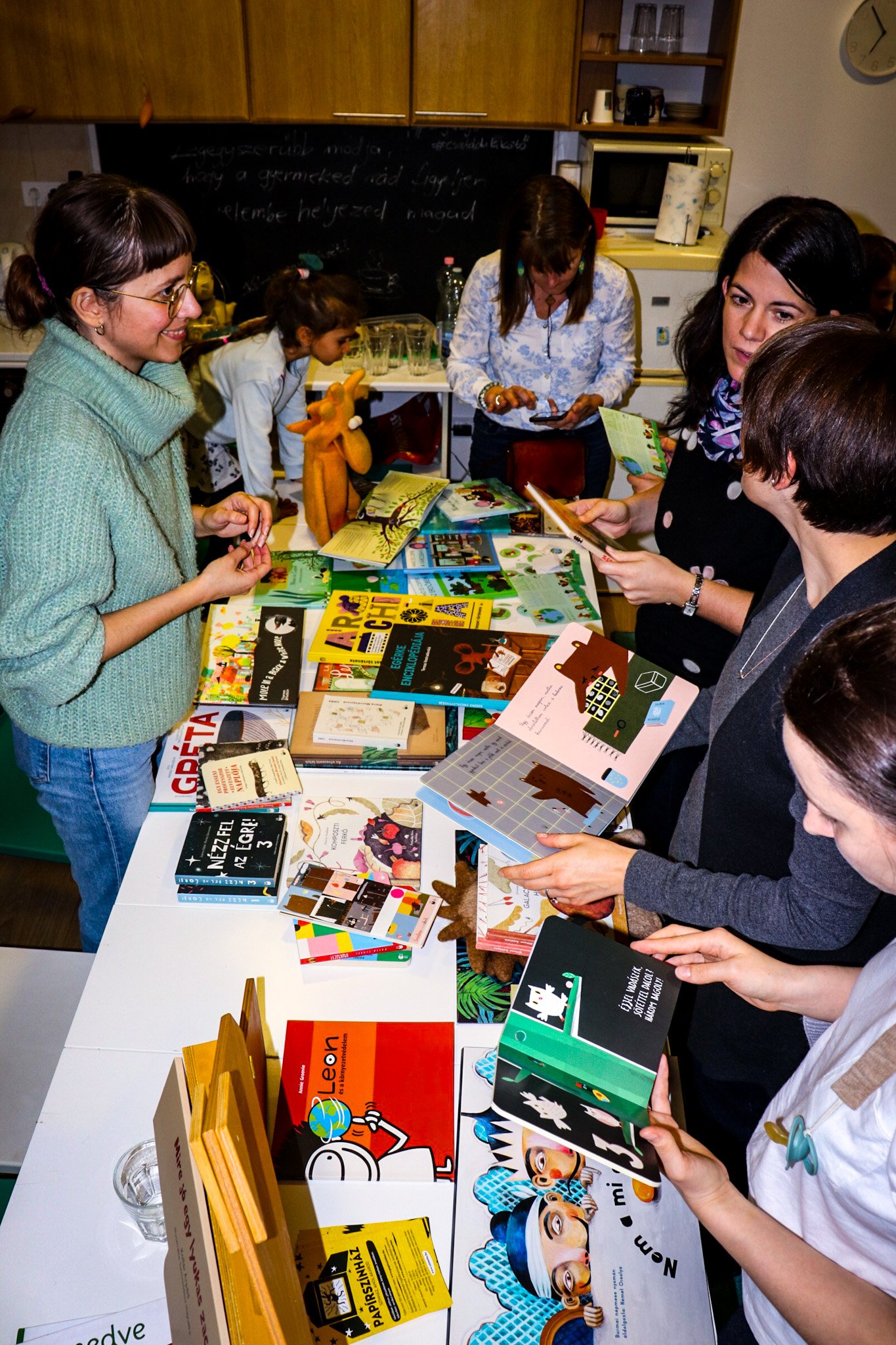 Peťovská Flóra from Csirimojó speaking with participants as they explore children’s books at the Anyahajó eco-storytelling event in Budapest.