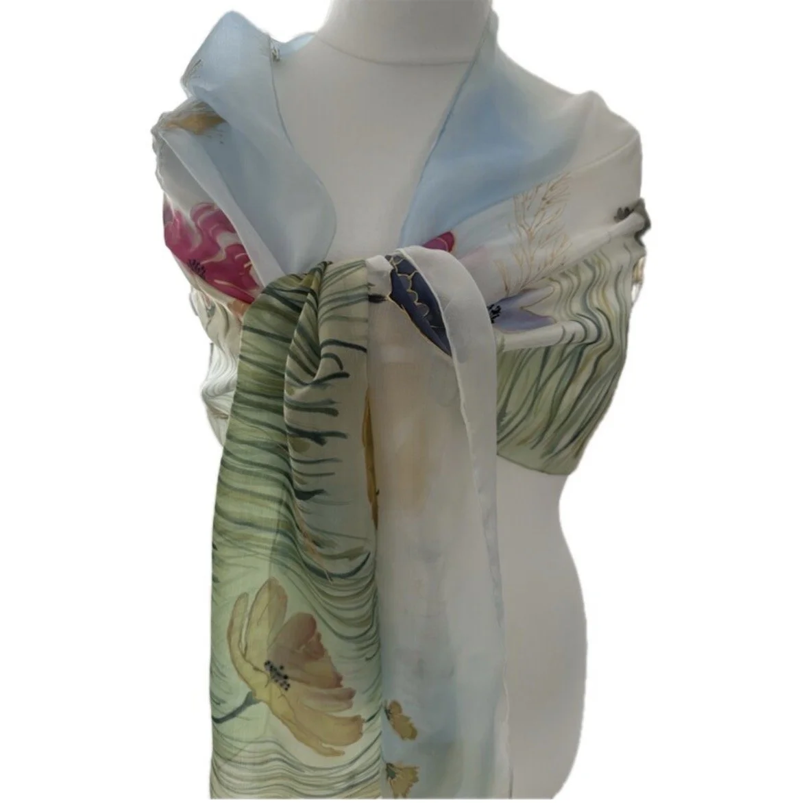 Mannequin wearing a white dress with a floral silk scarf draped over shoulders and tied in a knot at the chest, featuring colorful flower prints.