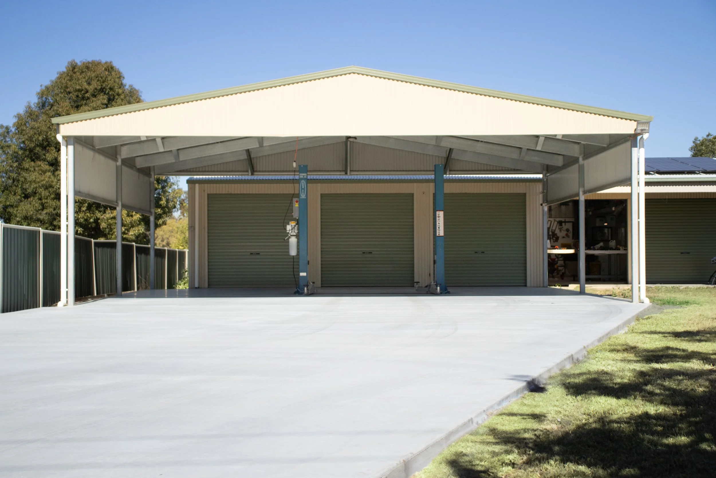 A three bay shed with extension and concrete driveway.