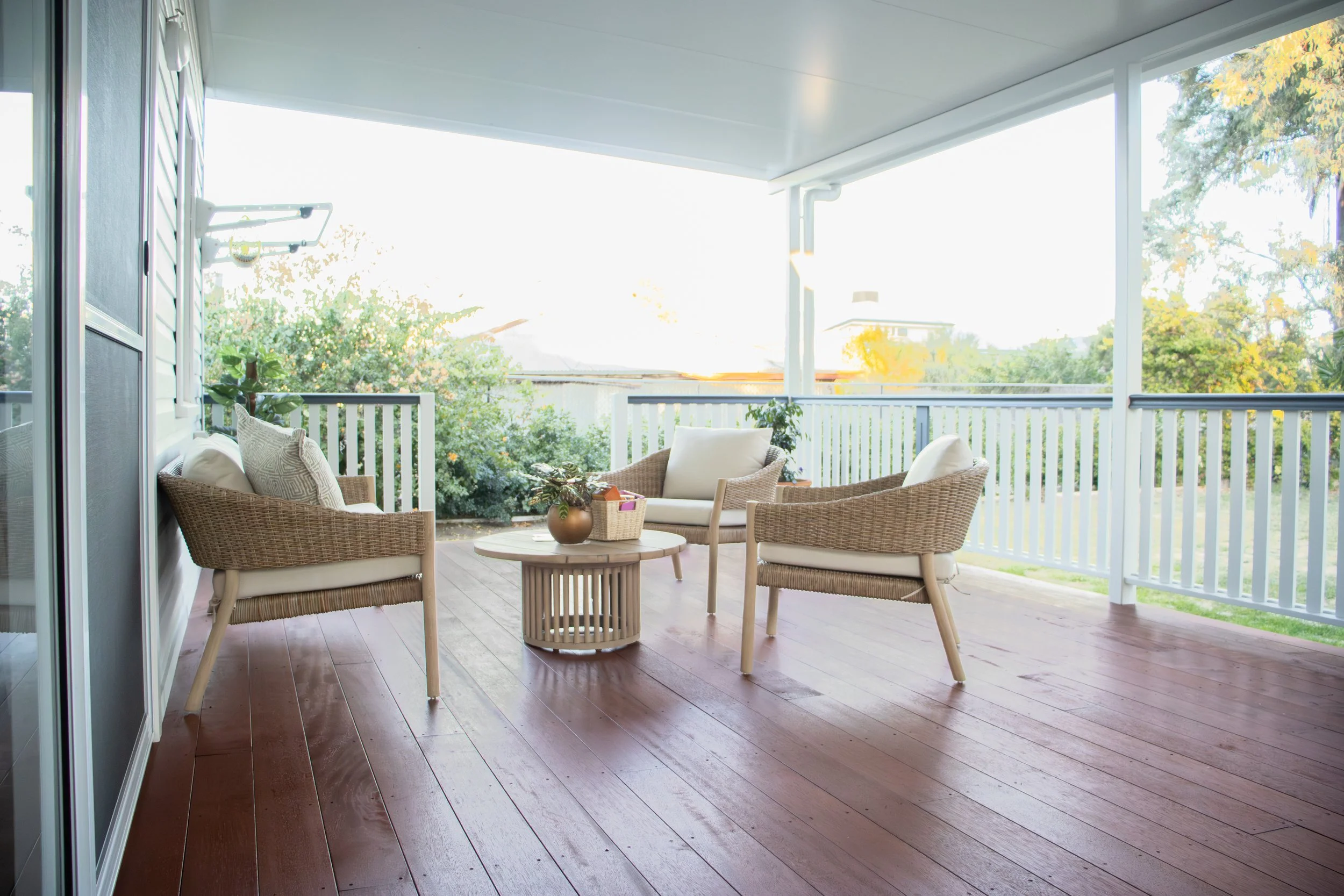A rear deck with merbau timber and white handrails.