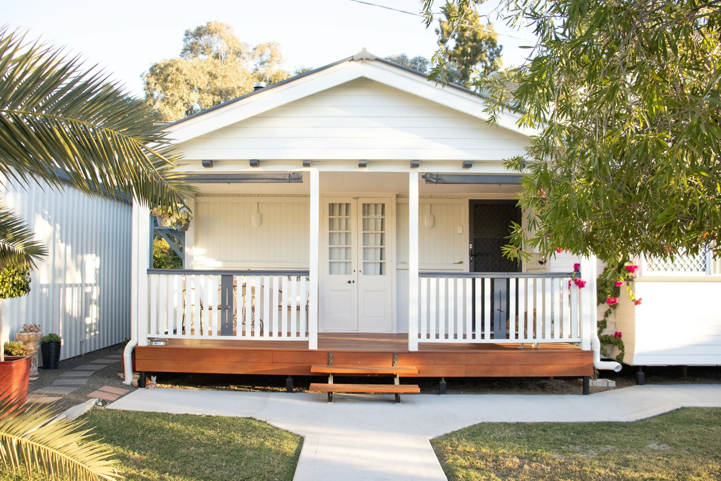 A front verandah on a Queenslander style home with merbau timber and french doors.