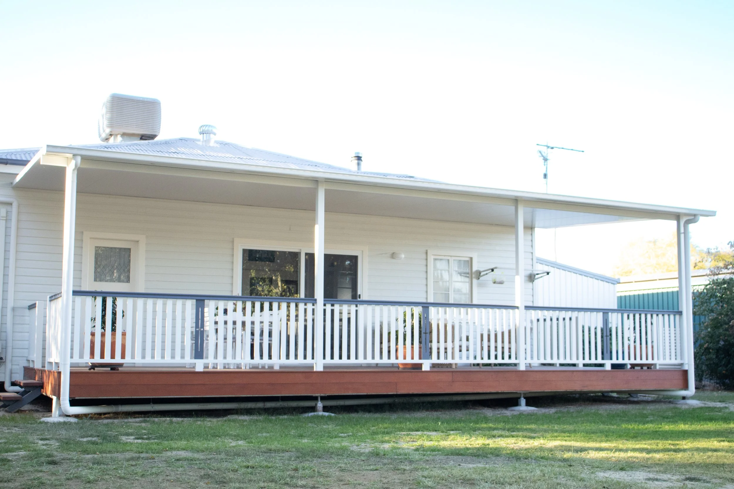 A rear deck with merbau timber and solarspan roof, with a glass sliding door.