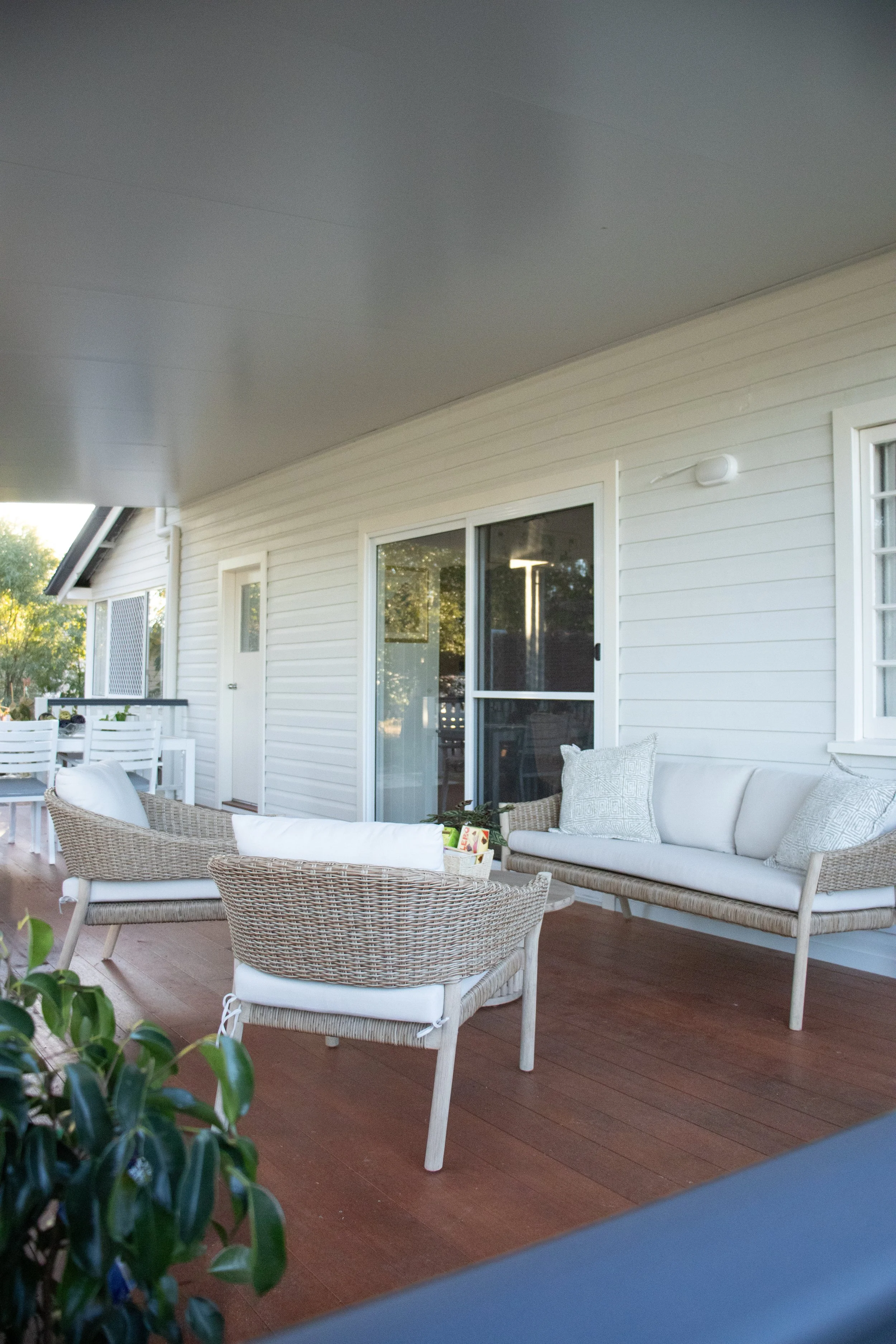 A merbau timber deck with sliding door and outdoor furniture.