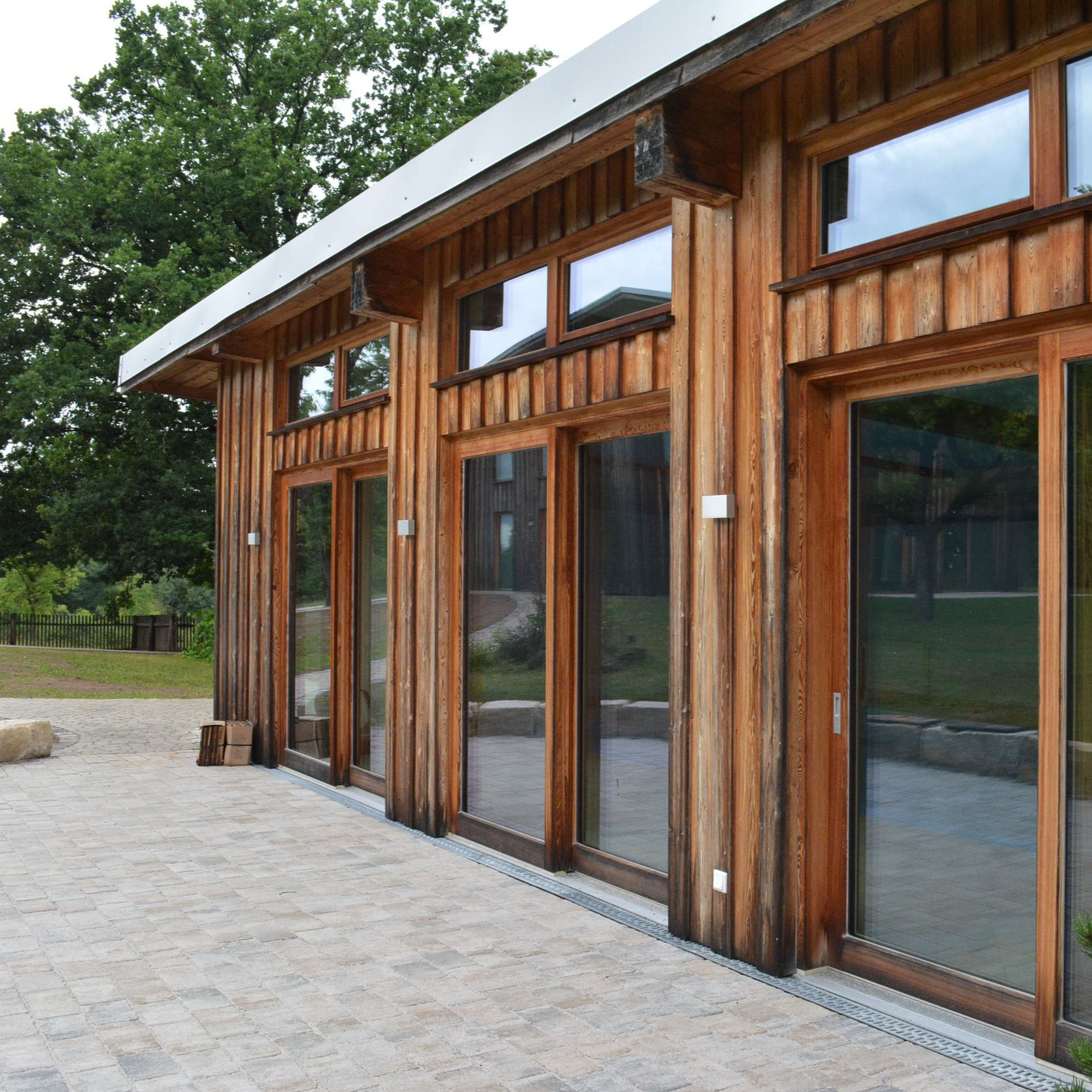 Holzfassade eines modernen Hauses mit großen Glasfenstern