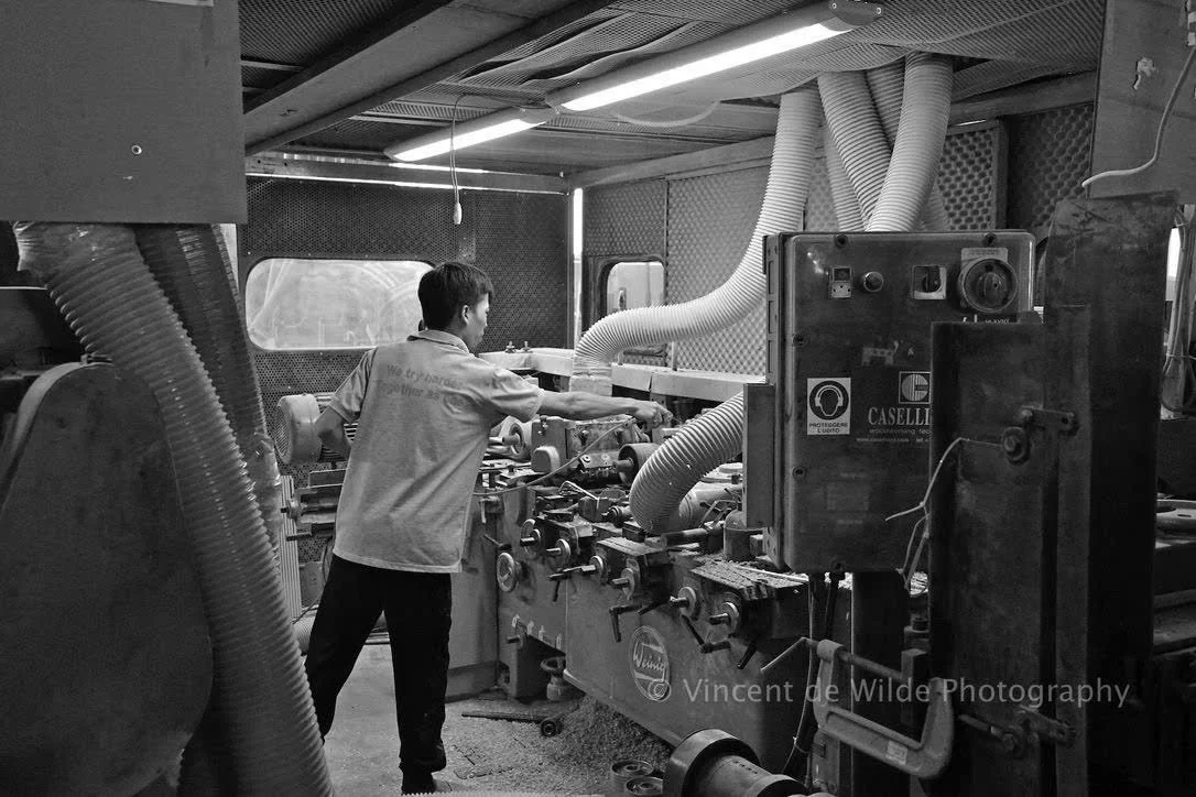 A man working with industrial machinery inside a workshop with various tubes and equipment.