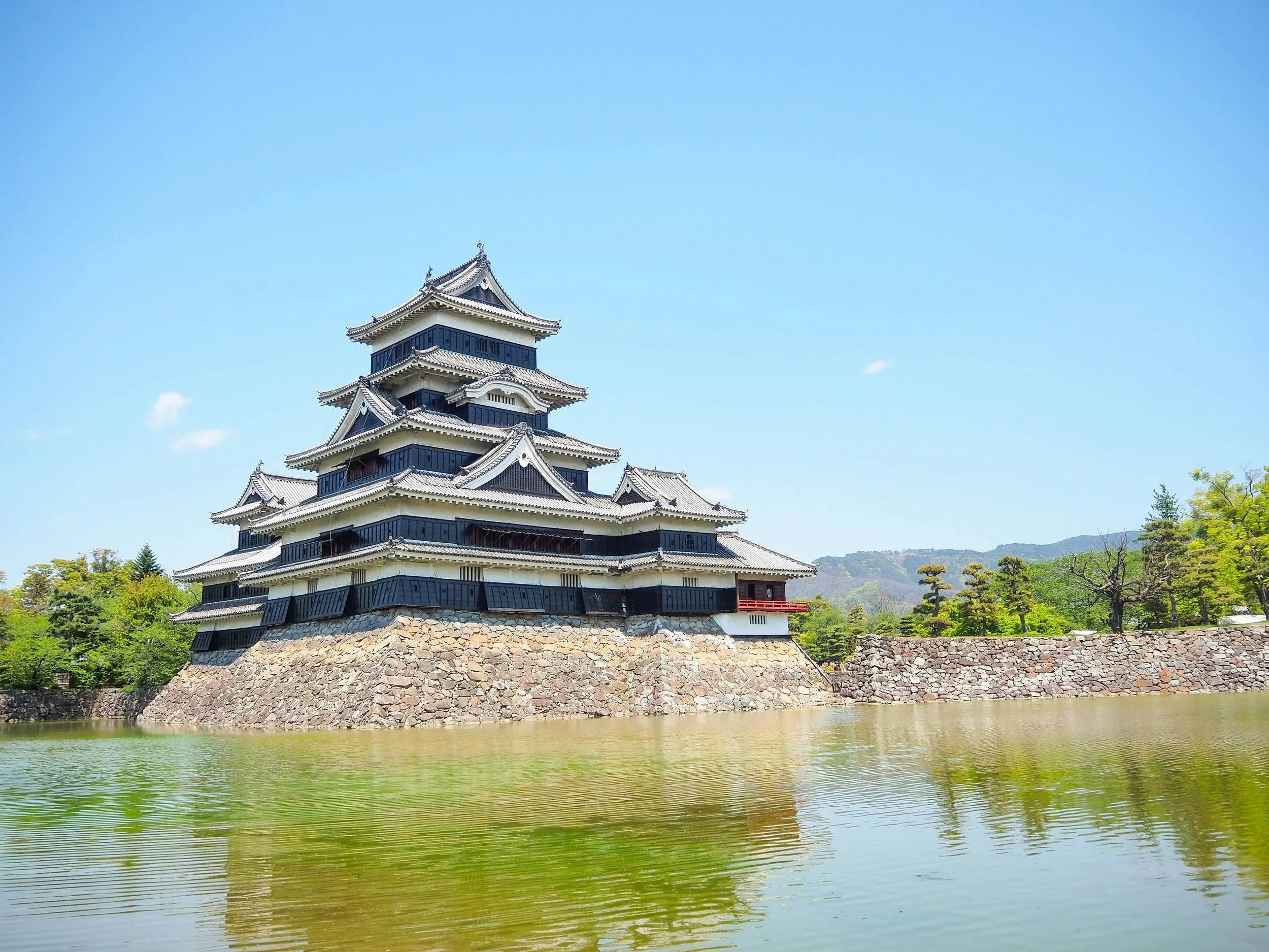 Matsumoto Castle reflected in the moat on a clear day