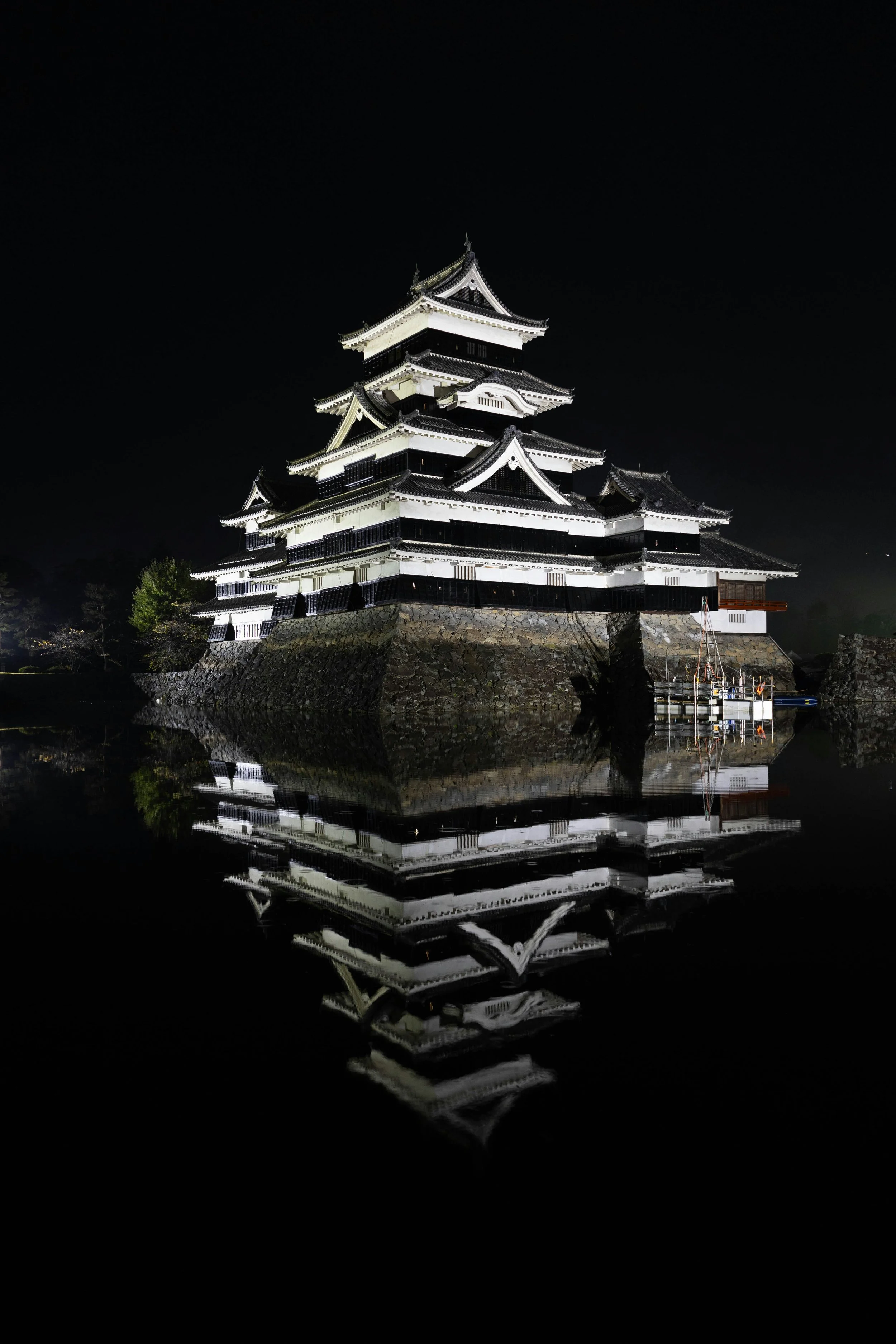 Matsumoto Castle illuminated at night with reflection in the moat