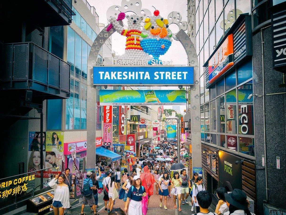 Takeshita Street entrance arch in Harajuku with shoppers below