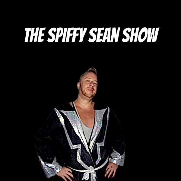 Man standing with hands on hips, wearing a shiny black robe with silver accents, against a black background with white text that reads 'The Spiffy Sean Show'.