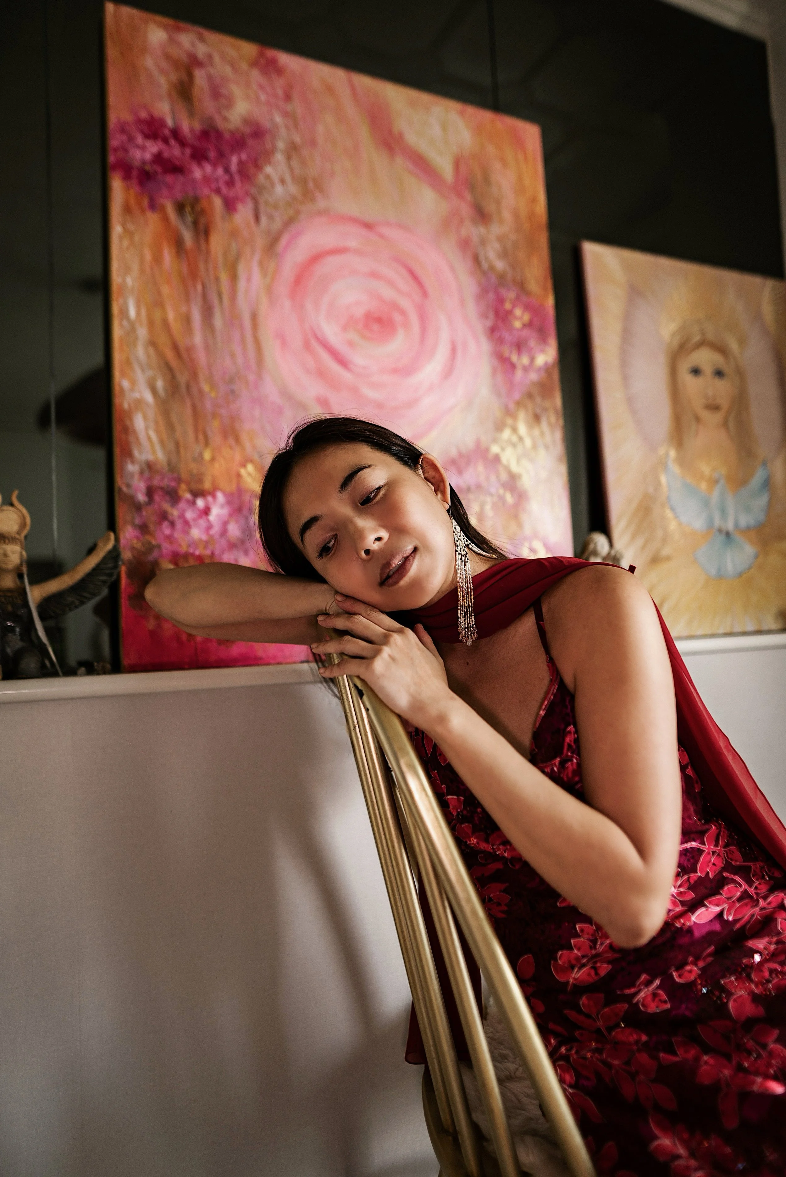 A woman in a red dress sitting down and leaning onto a chair, illustrating upcoming reiki trainings in bangkok, thailand.