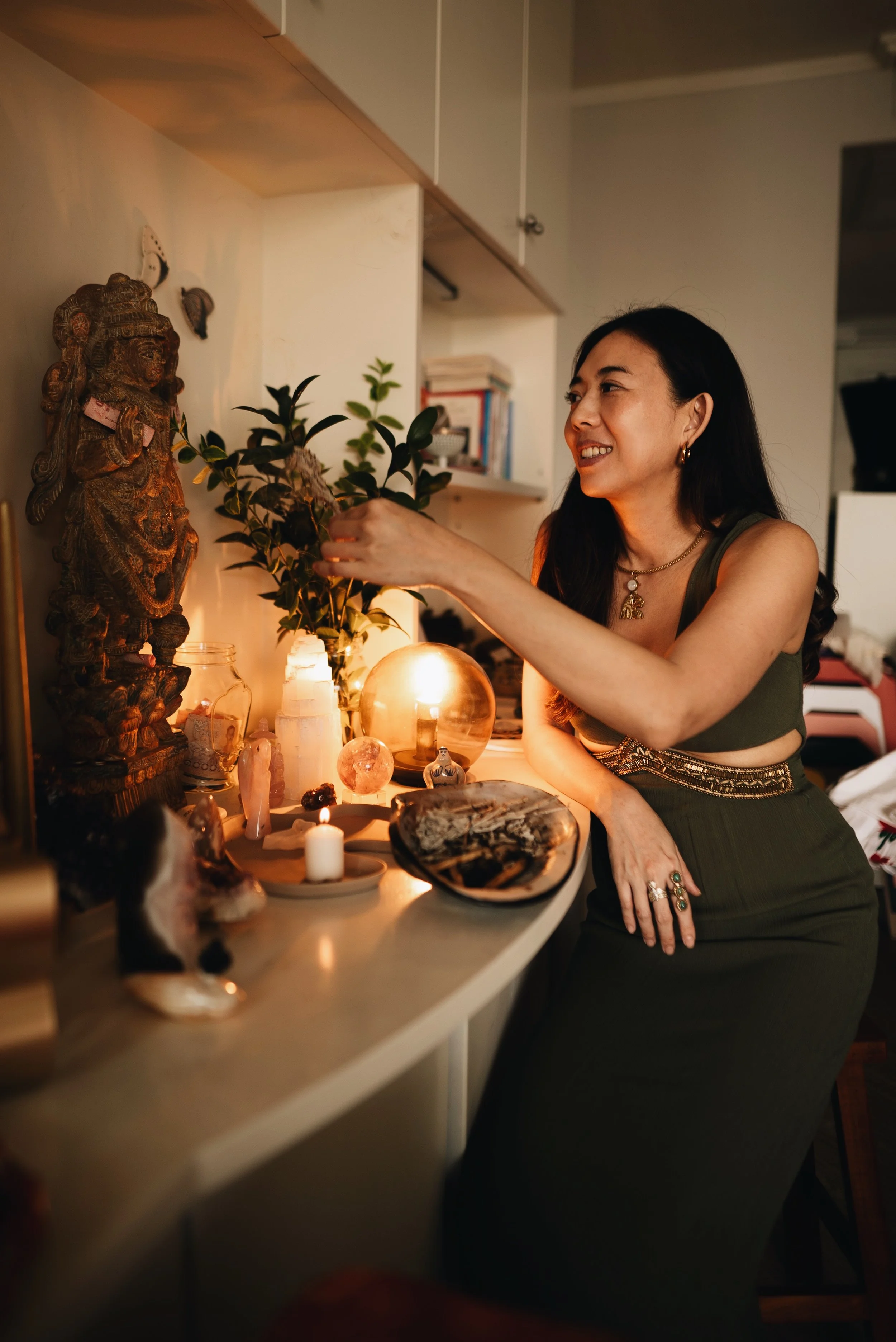 A woman in a sacred space at her altar, illustrating Aura Healing, Psychic Awareness Development, Psychometry, Crystal Healing and Pendulum Training for Healers.