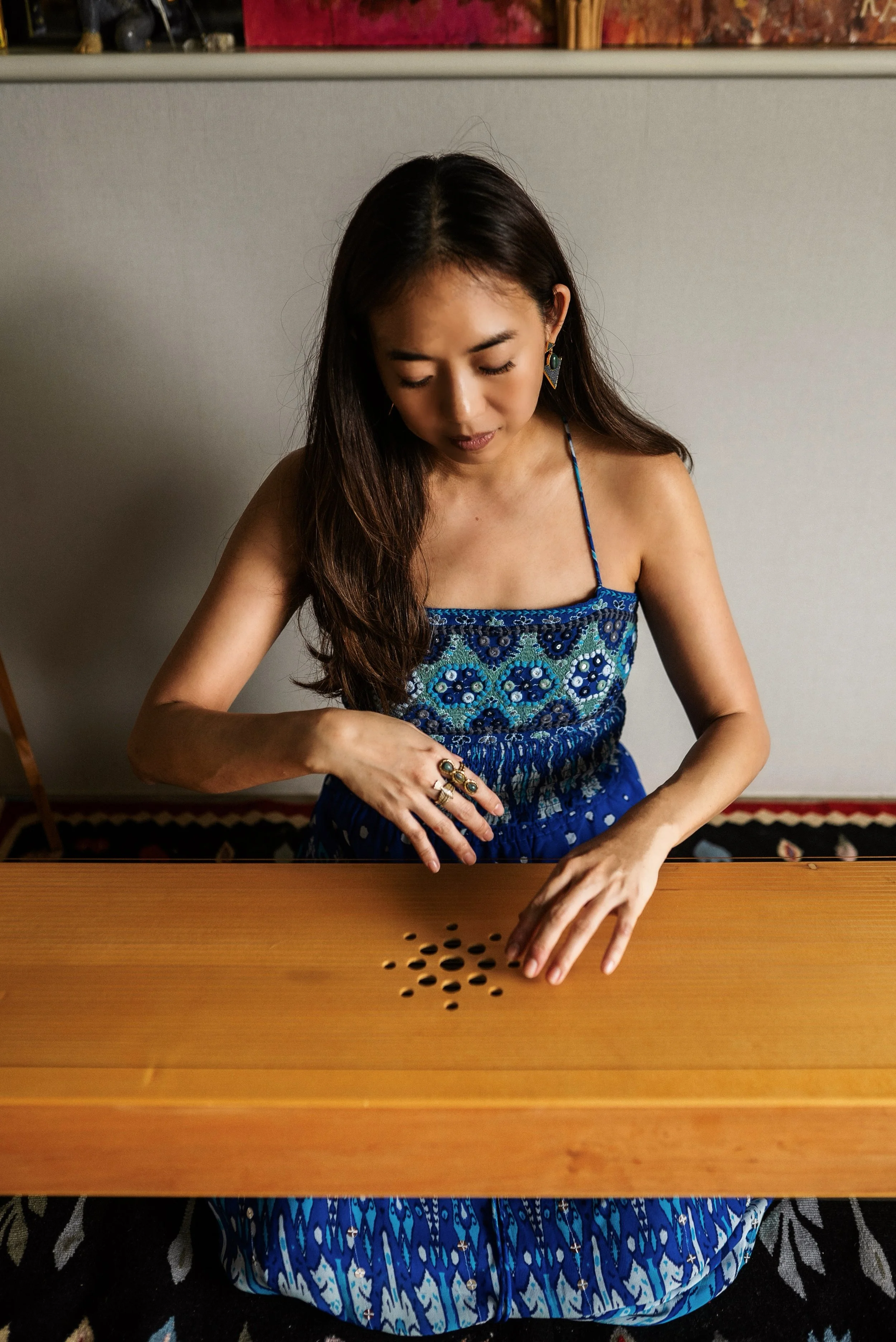 A woman playing a monocord music instrument illustrating monocord sound healing private or couple's session in bangkok, thailand