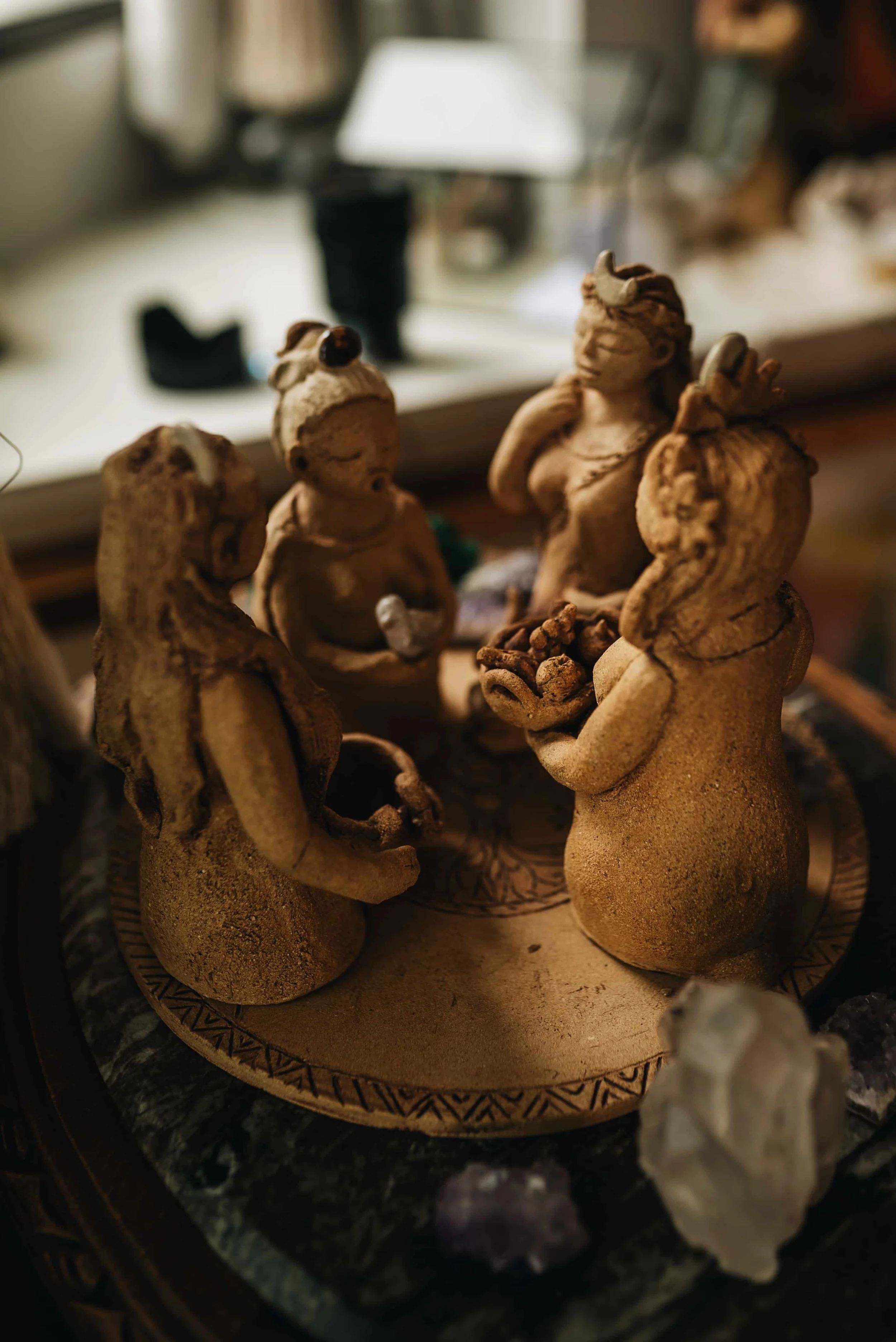 a stone statue of female figures holding hands