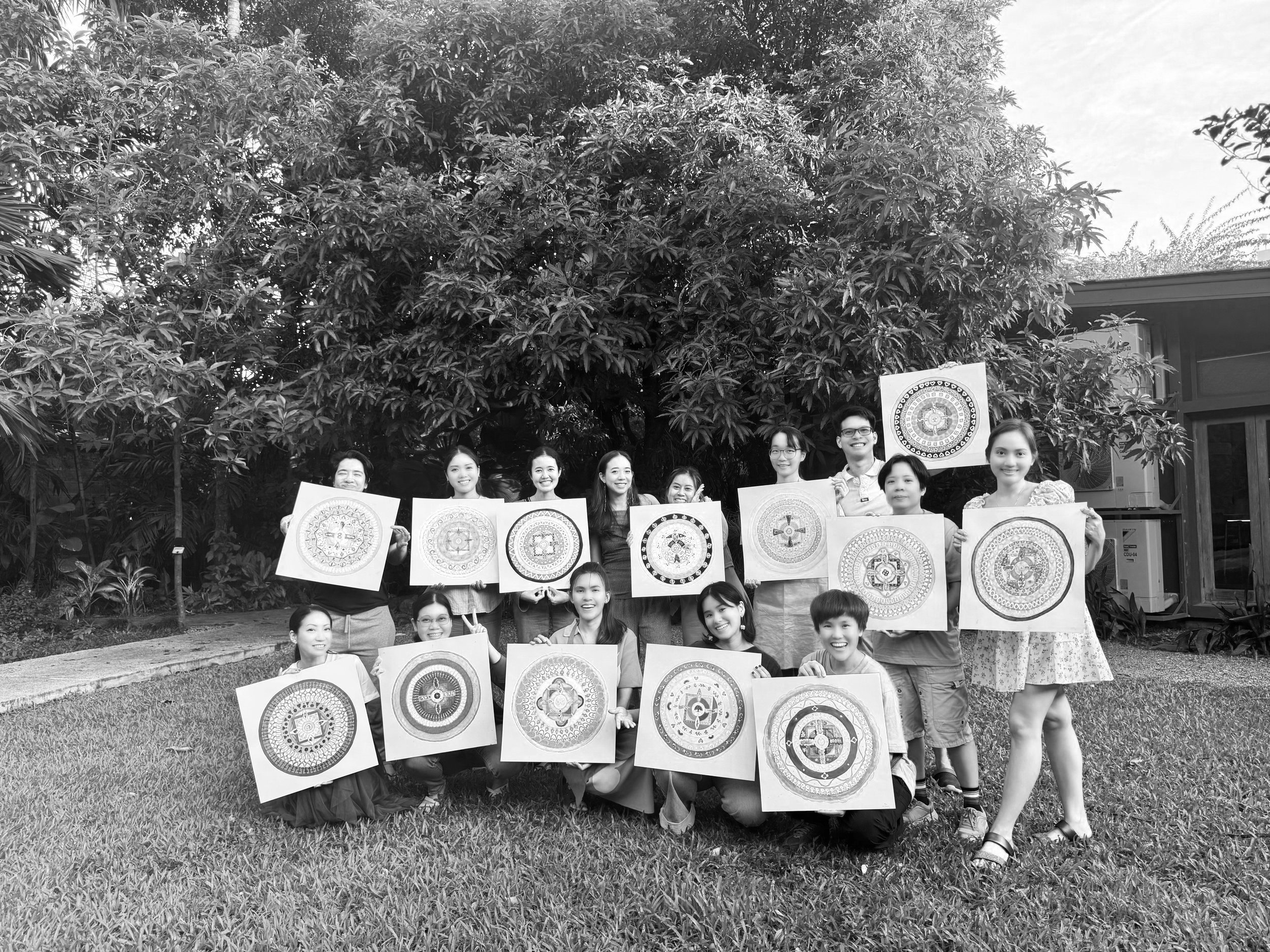 black and white group photo of students holding their mandala paintings