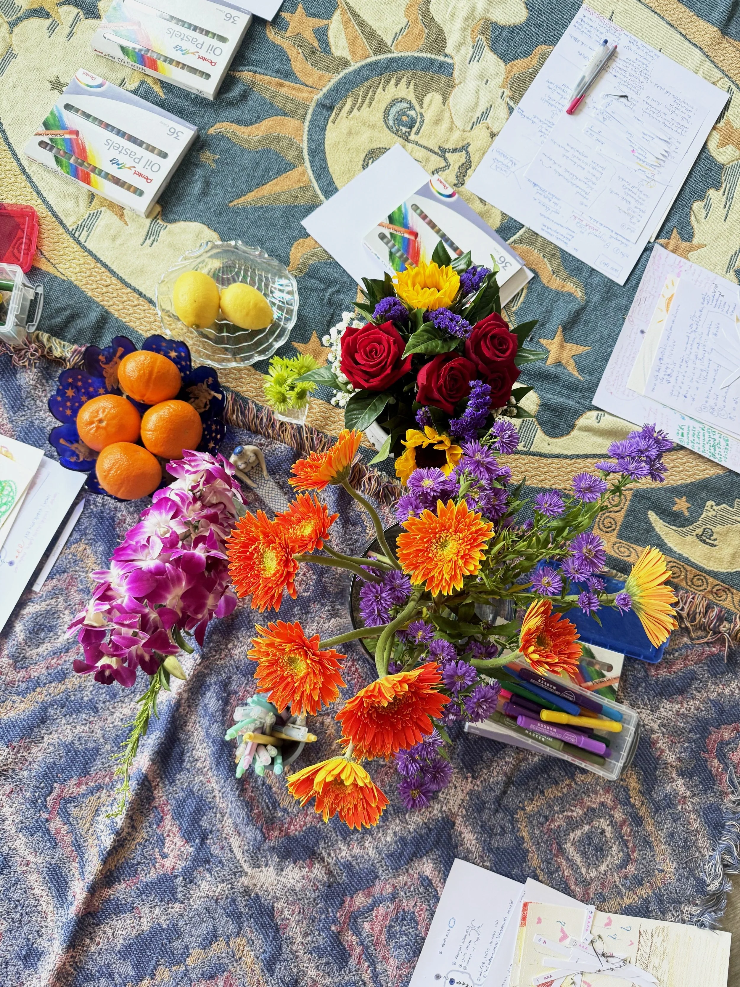 flowers, frutis and art supplies on a blanket, illustrating an aura vision training in bangkok