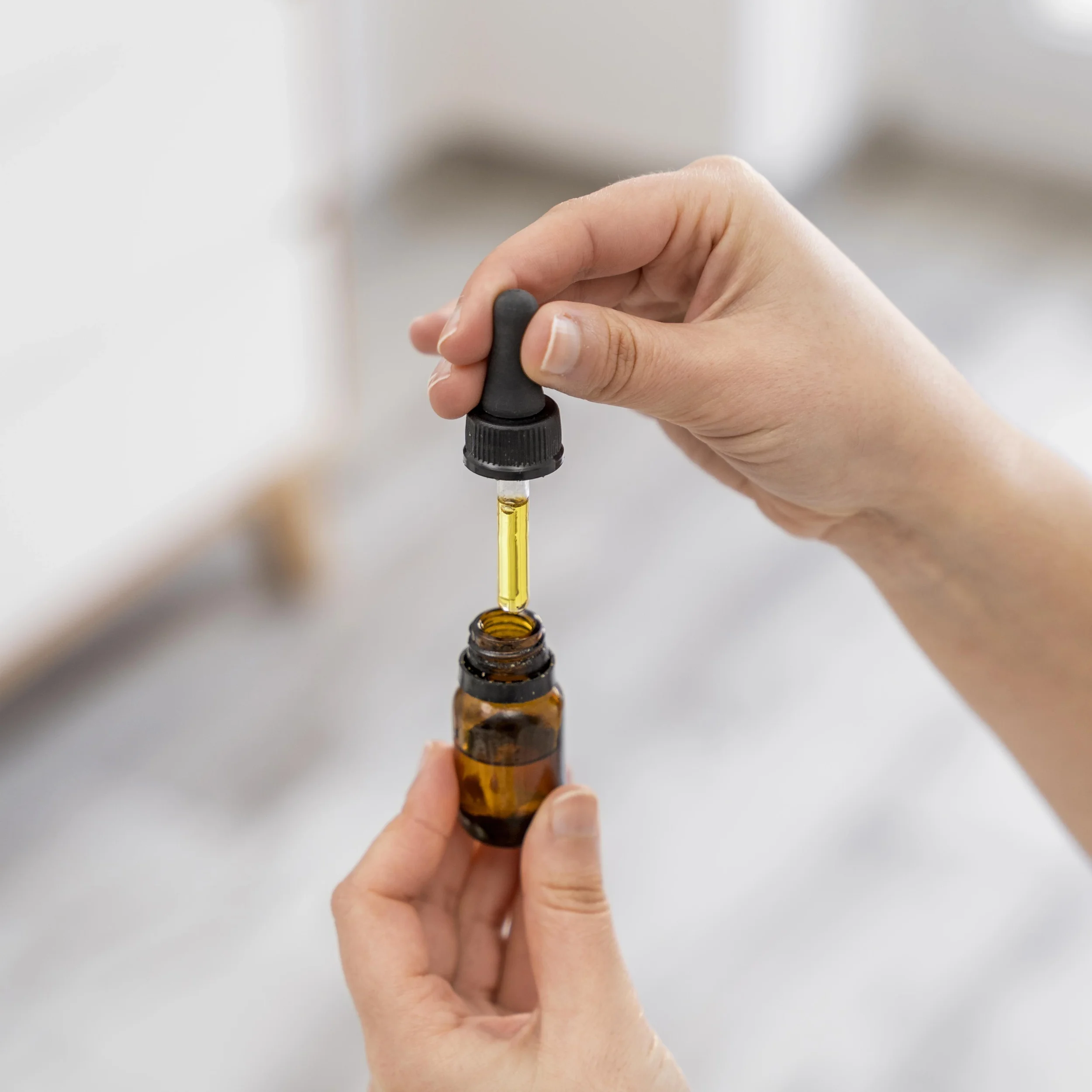 close up of hands holding an olive oil drop applicator