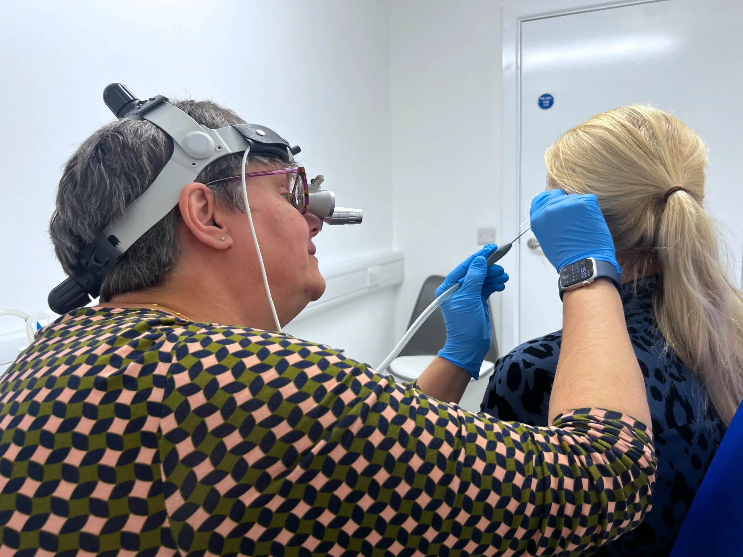 Andrew Bird Hearing's ear wax removal specialist Kate performing micro-suction on a patient