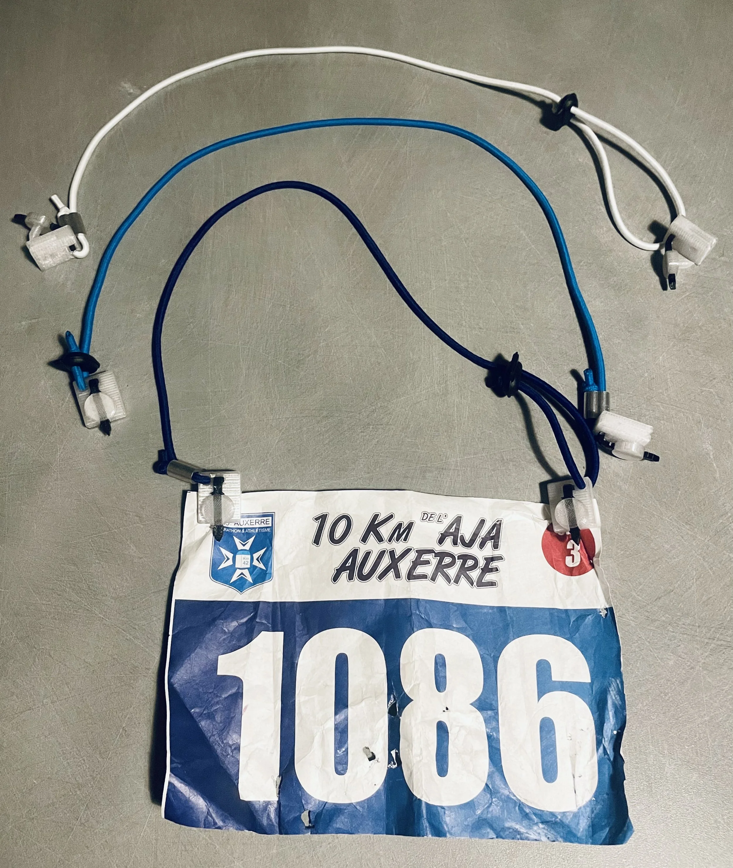 Porte dossard auto-perforant breveté