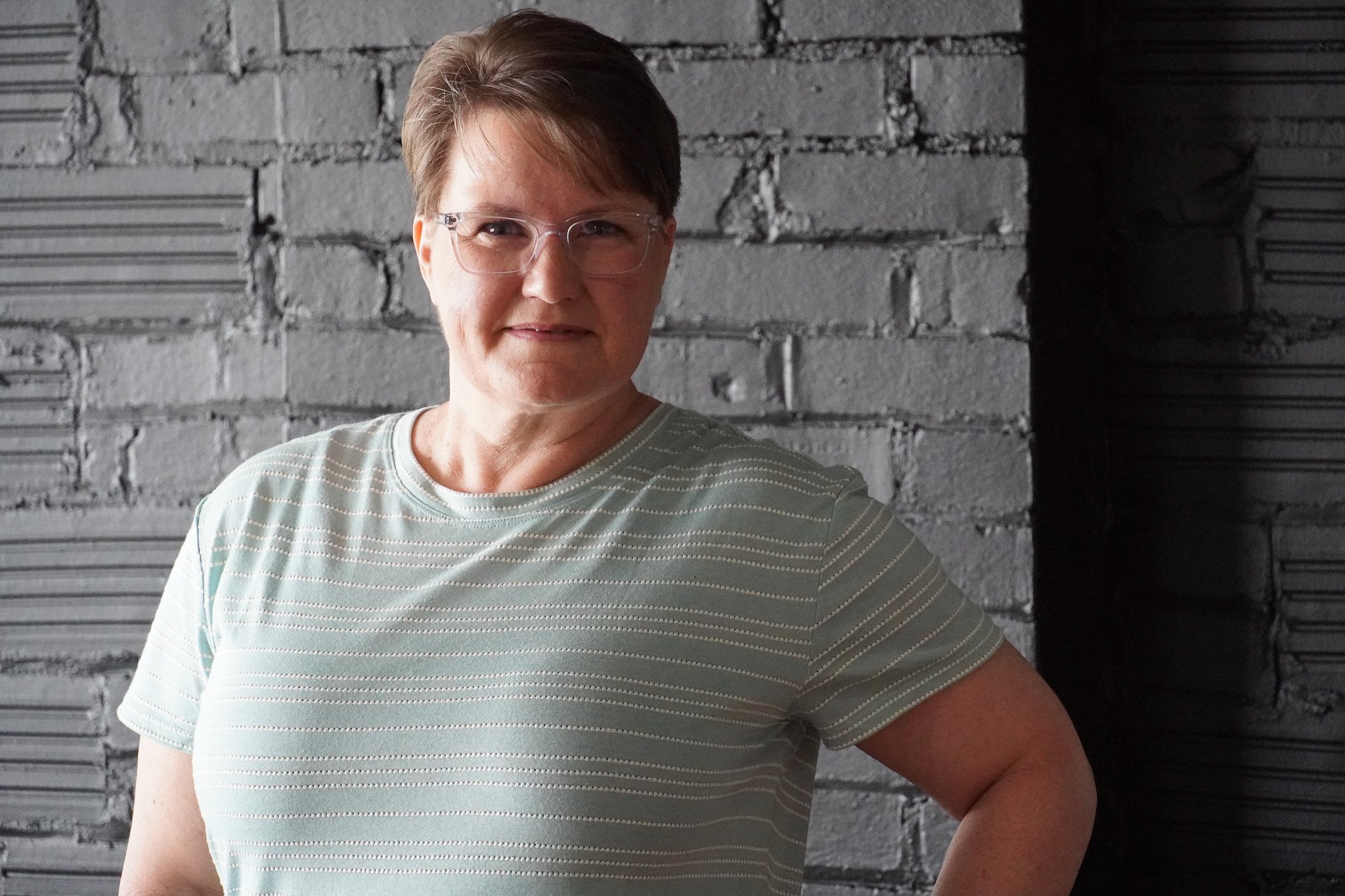 Woman standing with hand on hips and smiling