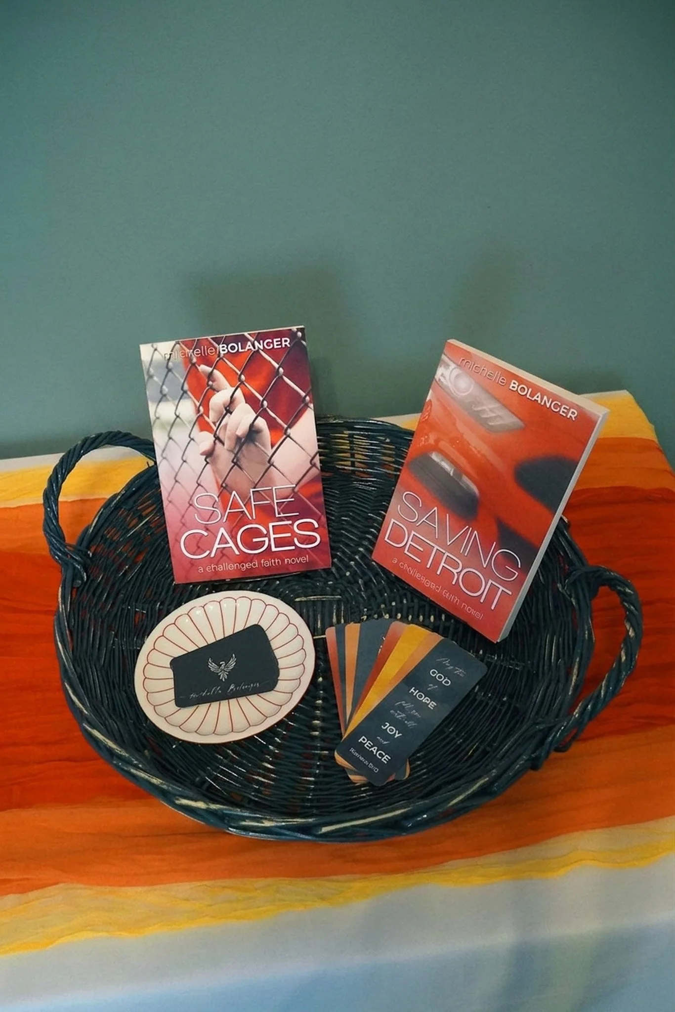 Two books in a basket with bookmarks, a saucer, and stack of business cards
