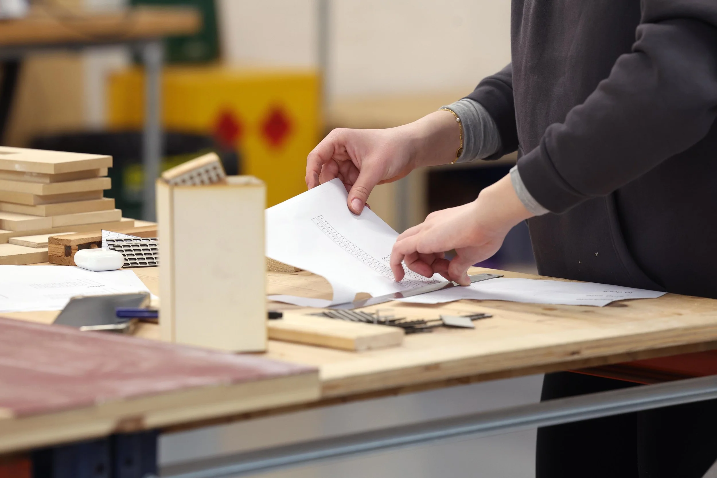 A woman handling drawings and models at Oxford Brookes