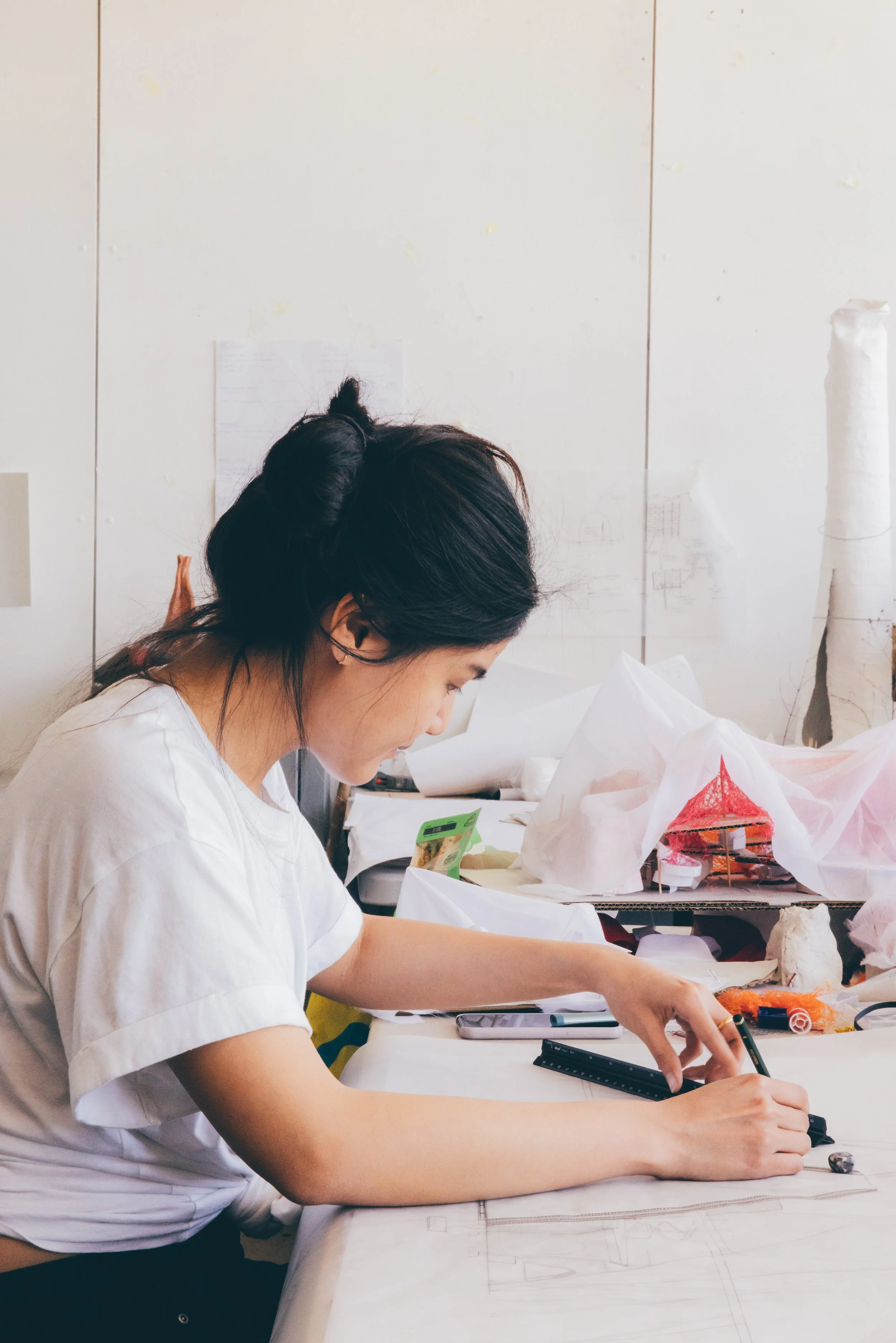 An architectural student at a desk drawing at Oxford Brookes studios