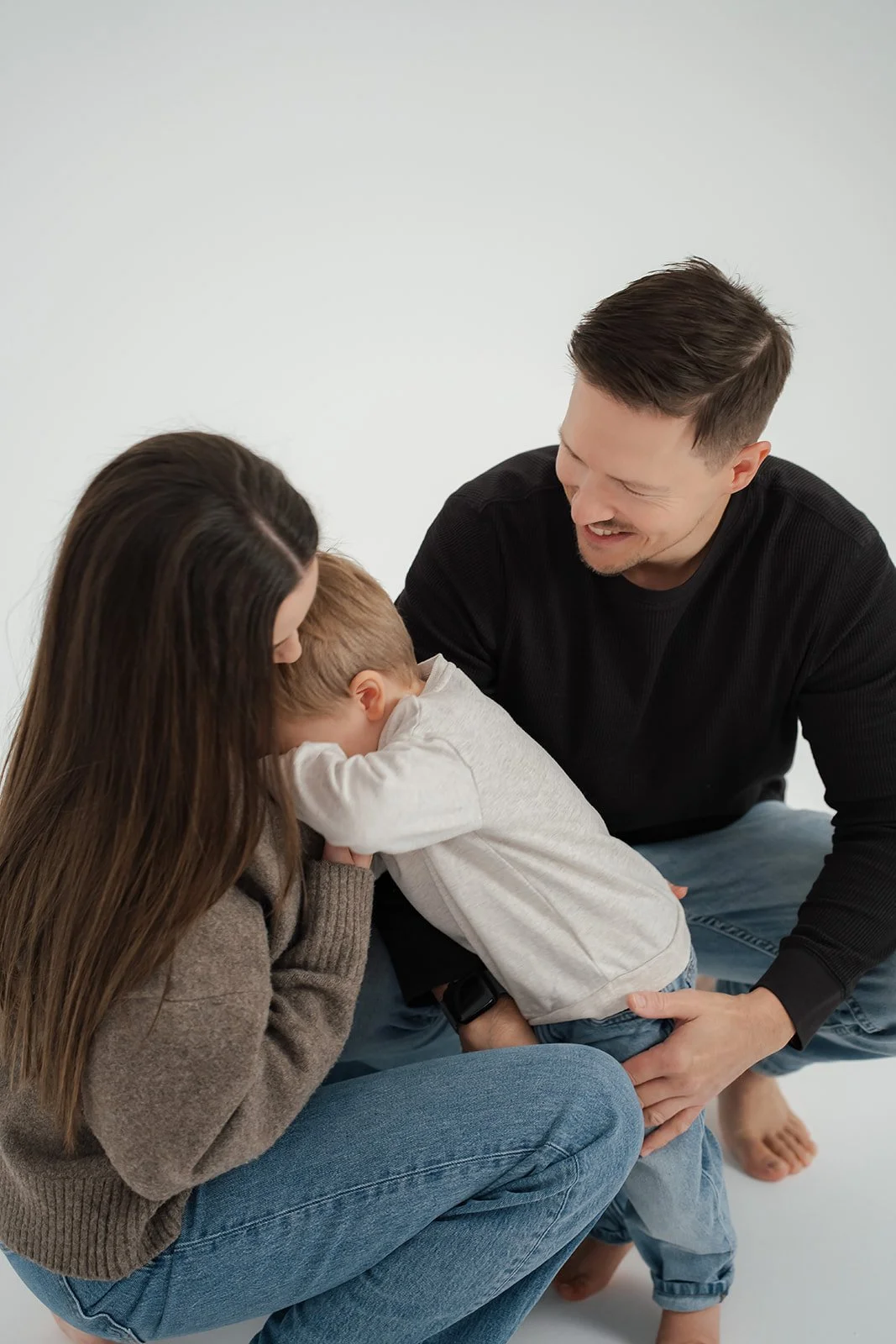 Familie umarmt und lächelt den kleinen Jungen.