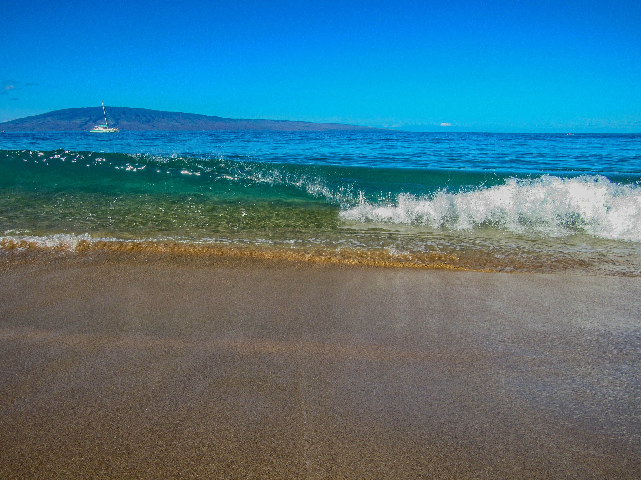 Breaking wave at Kāʻanapali Beach inviting visitors to explore Maui beaches by location, from the North Shore and Hāna to South and West Maui.