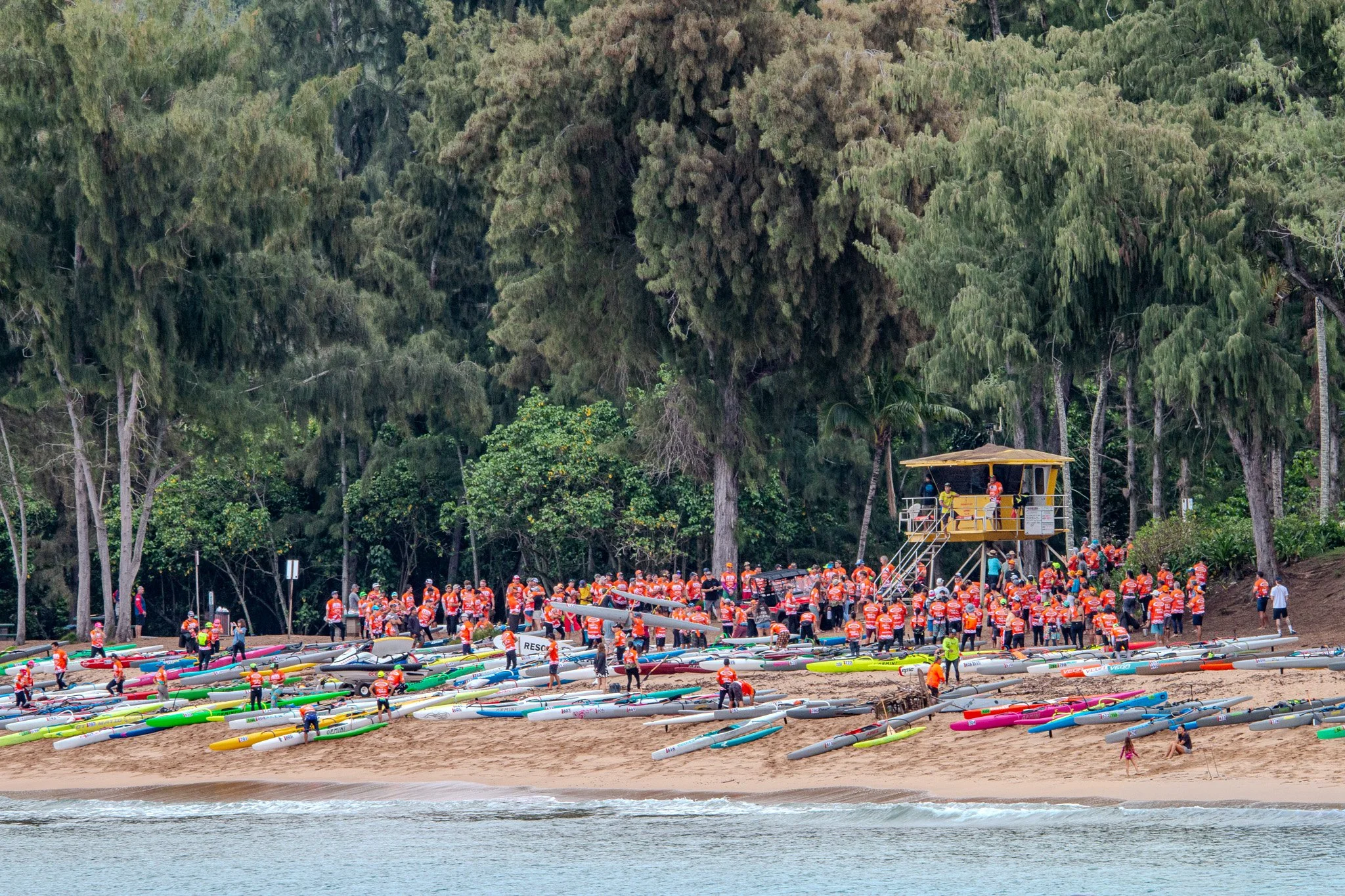 Ocean paddlers preparing for a race on the sandy shoreline of D.T. Fleming Beach along Maui’s northwest coast