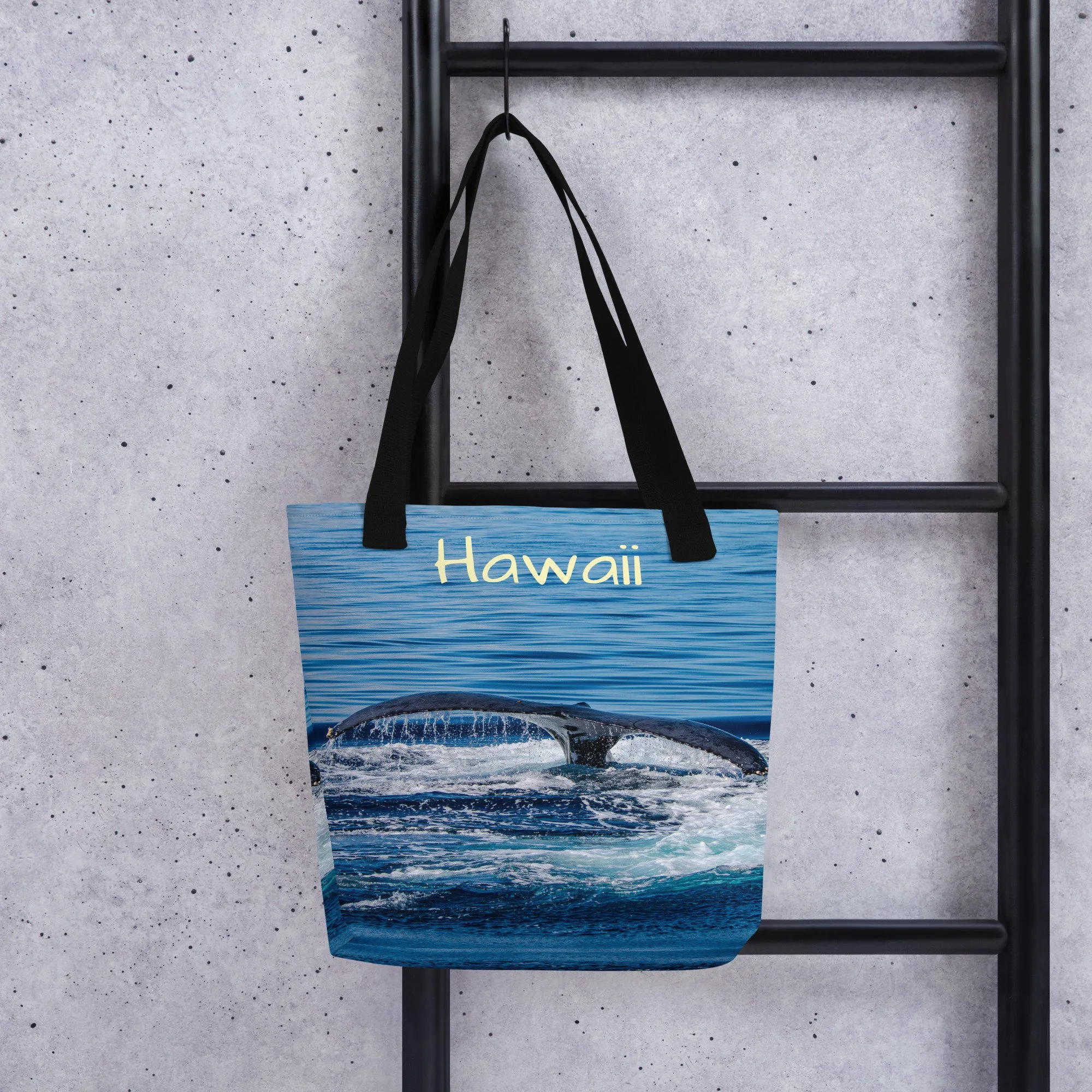 A vibrant Hawaiian tote bag featuring a humpback whale's tail as it splashes into the ocean. Lightweight, durable, and perfect for beach days, travel, or eveyday use around town.