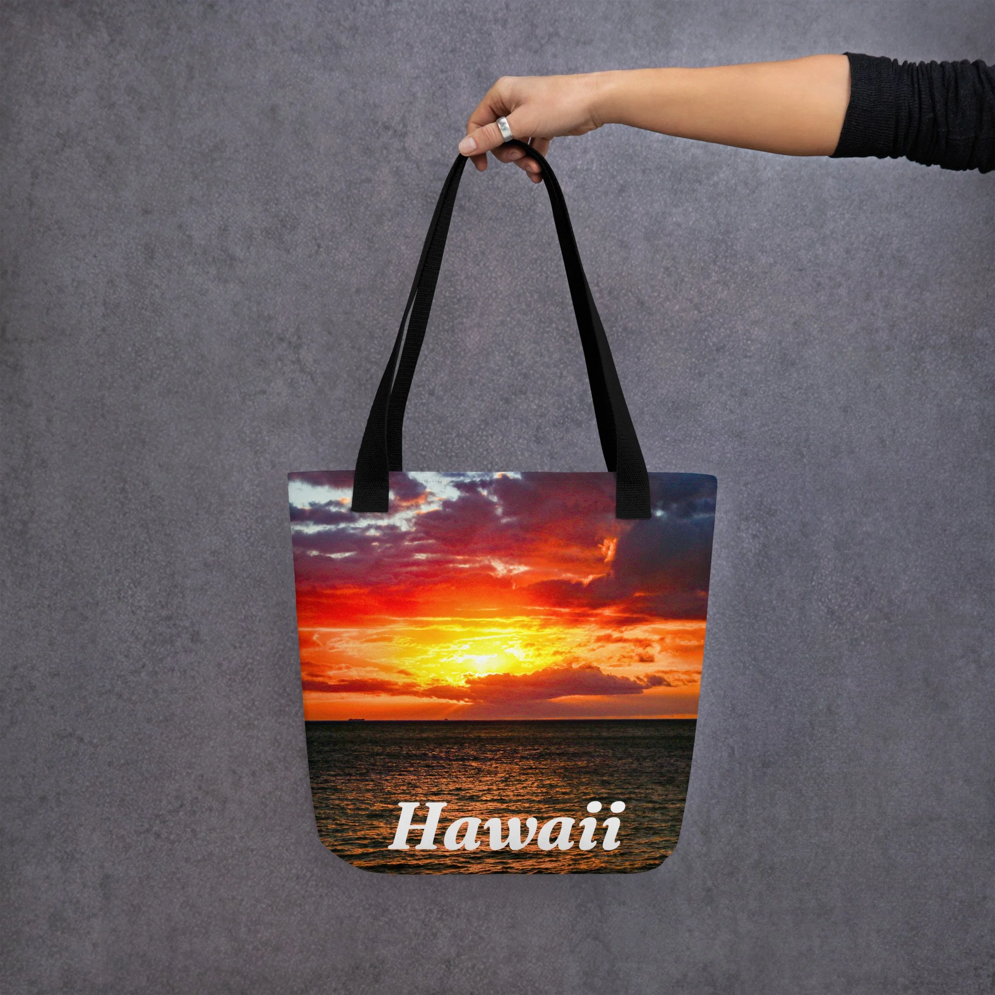 A vibrant Hawaiian sunset tote bag featuring rich red and gold skies over the ocean. Durable, lightweight, and perfect for beach days, shopping trips, or everyday carry.