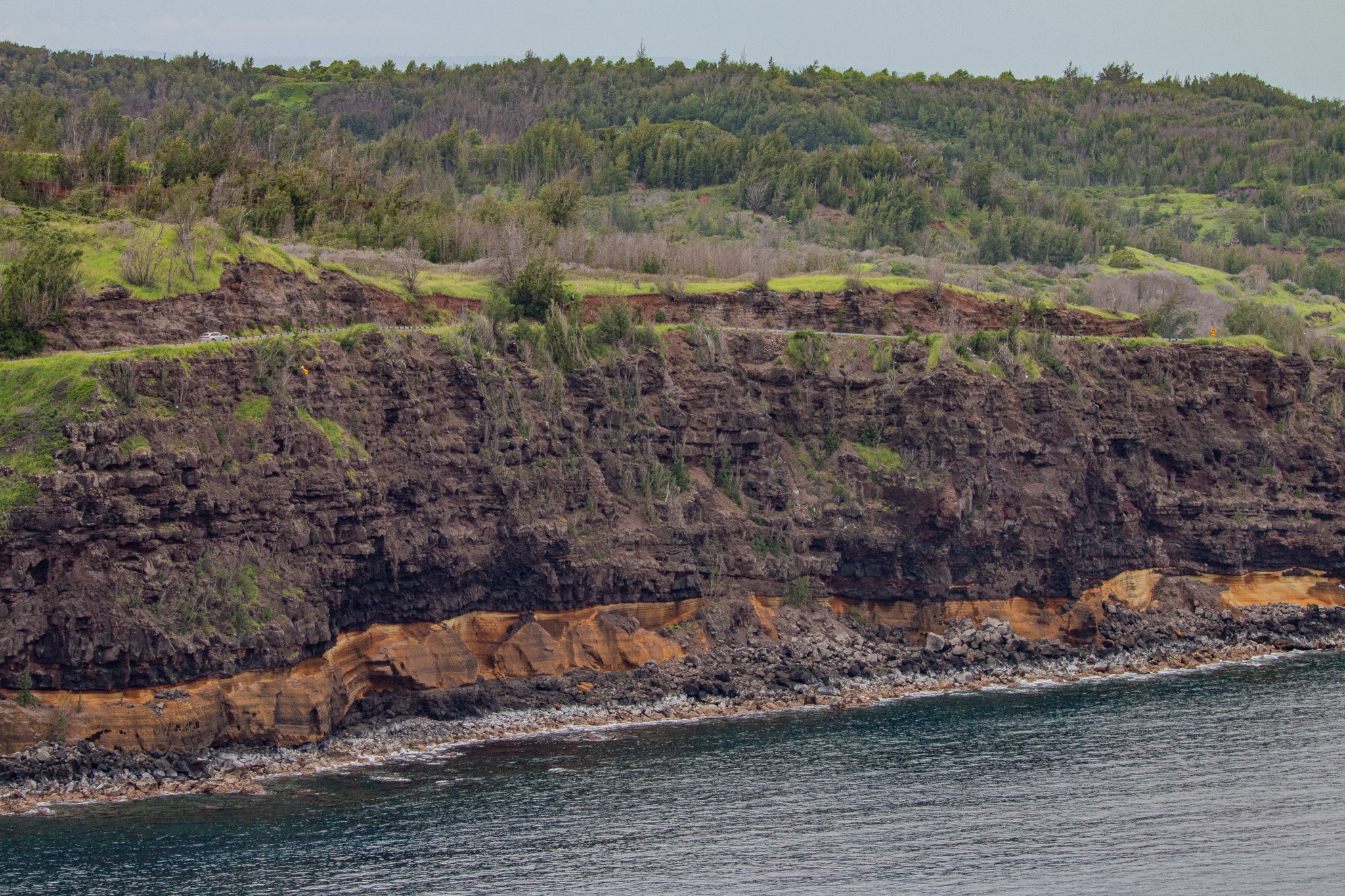 Layered volcanic cliffs and coastal rock formations along the shoreline near Nakalele Point on Maui’s northwest coast