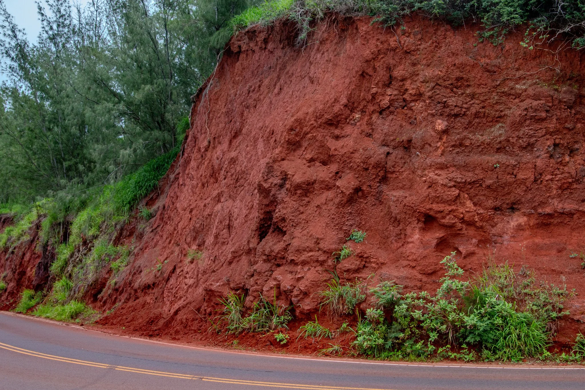 Deep red volcanic soil exposed along the coastal road near Nakalele Point on Maui’s rugged northwest shoreline