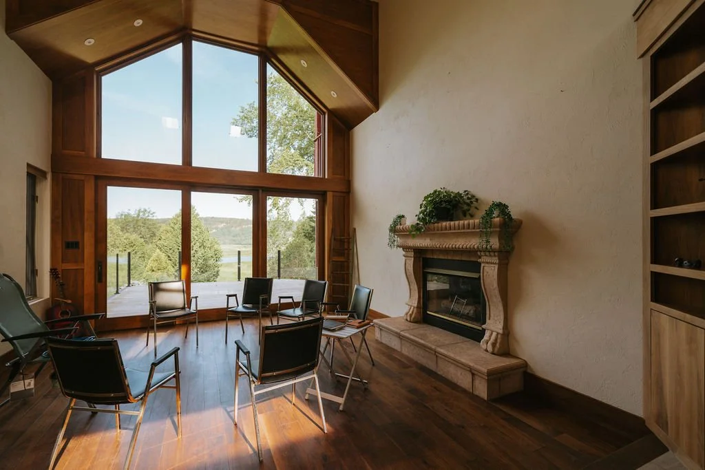 Main gathering space with soaring ceilings, fireplace, and natural light.